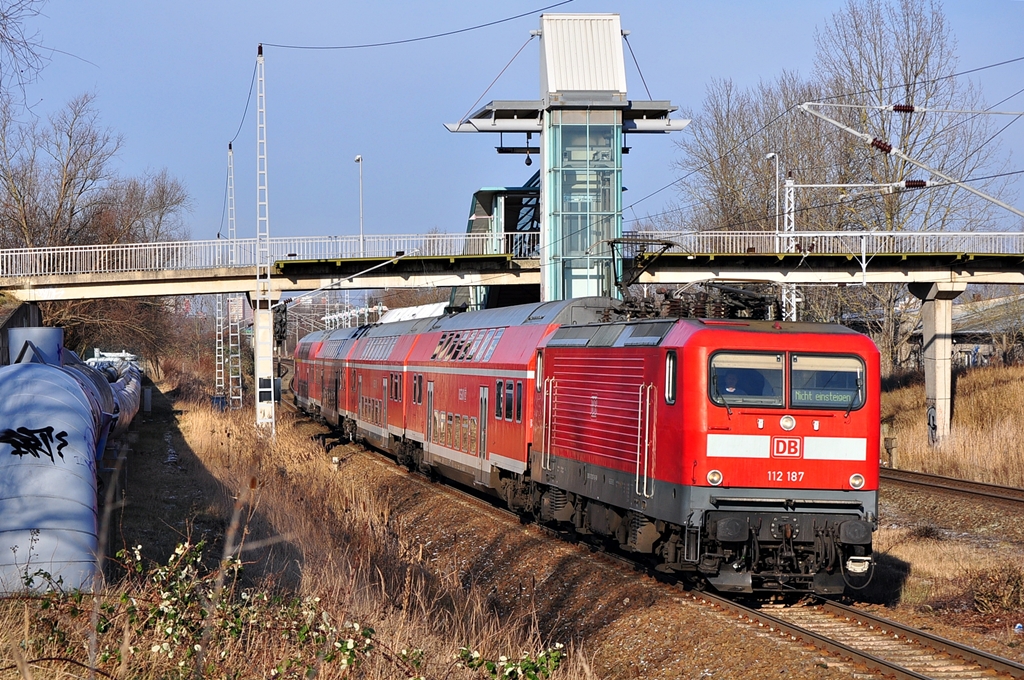 Die Cottbuser 112 187 hat den  Warnemünde-Express  als RE 18590 aus Berlin nach Warnemünde gebracht.Da in den Wintermonaten die Rückfahrt nach Berlin erst am Sonntag erfolgt,wird der Zug im Bw Rostock Hbf abgestellt.Hier fährt der Leerpark am 25.01.2013 durch den S-Bahn Haltepunkt Rostock-Marienehe in Richtung Hbf.