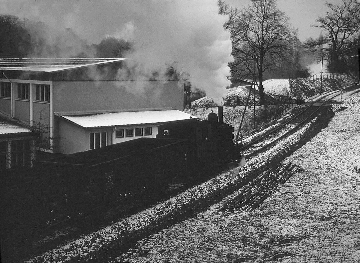 Die Dampflok der Gaswerkbahn Bern im Aufstieg vom Gaswerk nach Wabern, neben der Turnhalle Schönau, an der Aare. Dezember 1964 