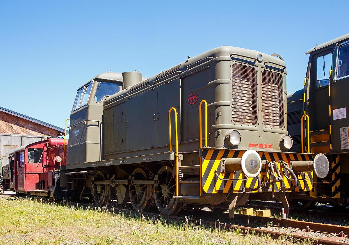 Die Deutz 56341 - eine DEUTZ  V6M 436 R Diesellokomotive, ehemals der Bundeswehr, am 06.05.2018 ausgestellt beim Erlebnisbahnhof Westerwald der Westerwälder Eisenbahnfreunde 44 508 e. V. hier war Museumstag. Die Lok ist Eigentum vom Militärhistorisches Museum Dresden und eine Leihgabe an die Eisenbahnfreunde. In der Lokstation Westerburg findet man eine einzigartige Spezialsammlung von Schienenfahrzeugen der Bundeswehr.

Die Lok wurde 1957 bei Deutz unter der Fabriknummer 56341 gebaut und an die Bundeswehr (Munitionsdepot Nord Löbbersted)  ausgeliefert, 2007 wurde sie außer Dienst gestellt und ging 2008 ans Militärhistorische Museum Dresden.

Nach Beseitigung der schwersten Kriegsschäden war die Klöckner-Humbold-Deutz AG als erste große deutsche Diesellokfabrik ab Anfang 1946 wieder fabrikationsfähig. Zunächst konzentrierte man sich auf die Fertigstellung bereits begonnener Fahrzeuge. Nach der Produktionsfreigabe durch die Besatzungsmächte begann man auch wieder mit Neuanfertigungen. Hierbei orientierte man sich weitgehend an der bewährten Wehrmachtslokomotive WR 360, die bis 1954 nahezu unverändert, ab 1952 als V6M536R mit gerundeten Formen und ab 1954 als V6M436R und V6M536R mit völlig neuem Aussehen des Aufbaus angeboten wurde. Bis 1960 konnte Deutz von diesen V 36-Nachbauten insgesamt 34 Stück verkaufen, eine davon ist die Lokomotive 56341 des ehemaligen Munitionsdepots Lübberstedt.

Der Typenreihe KHD V6M436 wurde die Versorgungsnummer 2210-12-120-5654 zugeordnet.

In der Erfolgsbilanz der Lokomotiv - Lieferanten für die Bundeswehr steht die KHD - Klöckner-Humboldt-Deutz AG, Köln an erster Stelle, auch wenn es bei der KHD V6M 436 R in der 440 PS-Klasse bei diesem Einzelstück blieb. Im Rahmen der schon erwähnten Ausschreibung bot KHD 1956 eine V6M 436 R zum Stückpreis von DM 335.620,-- an. Die Auftragserteilung erfolgte im August 1956, der schon am 03.03.1957 die Auslieferung an das Munitionsdepot Lübberstedt folgte. Die Lokomotive ist seit der Inbetriebsetzung stets im MunDepot Lübberstedt im Einsatz gewesen. 

Nennenswerte Ausfälle der Lokomotive traten in den Jahren 1994 und 1998 jeweils durch Motorschäden auf. Aber auch hier gelang der MaK - Rahmenvertragswerkstatt Moers stets die Instandsetzung des Fahrzeuges, obwohl die entsprechenden Originalersatzteile nicht mehr verfügbar sind. Die letzten Hauptuntersuchungen wurden in den Jahren 1978, 1986 und 1993 in Moers durchgeführt. Infolge eines neuerlichen Motorschadens kam die Lok am 29.06.1998 in die Moerser Werkstatt, auch diesmal gelang es den Schaden zu beheben. Nach einem 16-monatigen Werkstattaufenthalt hat sie mit HU-Datum vom 21.10.1999 wieder den Weg zum Munitionsdepot Lübberstedt angetreten. Mit Fristablauf Oktober 2008 wurde die Maschine abgestellt und wegen der Schließung des Depots die Aussonderung vorbereitet. Das Militärhistorische Museum Dresden übernahm diesen technischen Zeitzeugen und übergab die Lok in die Spezialsammlung der WEF 44 508 e. V. in Westerburg. Am 23.12.2008 erreichte die Maschine den Erlebnisbahnhof Westerwald und kann seitdem von der Allgemeinheit besichtigt werden. Die Westerwälder Eisenbahnfreunde haben viele Mühen für die Erhaltung der Lokomotive auf sich genommen, schließlich ist sie das weltweit einzige noch betriebsfähige Exemplar

Quelle: http://www.bundeswehrloks.de/

Technik:
Die DEUTZ V6M 436 R ist eine dieselhydraulische, dreiachsige Starr-Rahmen-Lokomotive mit Endführerhaus. Die Kraftanlage besteht aus dem Deutz-6-Zylinder-Dieselmotor V6M 436 (360PS), der über eine elastische Kupplung das Flüssigkeitsgetriebe antreibt. Das verwendete Flüssigkeitsgetriebe ist ein Voith-Turbogetriebe der Type L 37U. Es besteht aus einem hydraulischen Drehmomentwandler und zwei hydraulischen Kupplungen mit selbsttätig wirkender Steuerung. Diesem Getriebe ist ein kombiniertes Stufen- und Wendegetriebe nachgeschaltet, in dem auch die Blindwelle gelagert ist. Von der Blindwelle aus werden die drei Radsätze mit Treib- und Kuppelstangen angetrieben.

Für das Starten des Motors, der mittels Druckluft angelassen wird, sind zwei Luftflaschen mit je 250 Litern Volumen vorhanden. Die Kühlanlage besteht aus dem Wasserkühler, dem Getriebeölkühler, dem Kühler für das Motorschmieröl und dem Lüfterrad. Die Lok besitzt außer der 6 - Klotz - Handspindelbremse eine durchgehende Druckluftbremse für Lokomotive und Zug sowie eine Druckluftzusatzbremse nur für die Lokomotive.

Die Beleuchtungsanlage der Lok wird aus einer Batterie gespeist, die durch eine ständig vom Motor angetriebene Lichtmaschine geladen wird. Die Lokomotive hat ein Dienstgewicht von etwa 42 Tonnen und erreicht auf gerader horizontaler Strecke im Verschiebedienst eine Maximalgeschwindigkeit von 34 km/h, sowie im Streckendienst von 51 km/h. 

Technische Daten:
Typ:  V6M 436 R (Bauform 1954)
Spurweite: 1.435 mm (Normalspur)
Länge über Puffer:   9.570 mm
Achsanzahl:  3 (C-dh)
Motor:  KHD wassergekühlter 6 Zylinder Reihenmotor
Mit 97,68 l Hubraum (vom Typ V6M 436 R)
Leistung: 360 PS bei 600 U/min
Getriebe: Voith-Turbo-Getriebe L 37 U
Antriebübertragung: s.o.
Dienstgewicht:  42 t
Höchstgeschwindigkeit: 51 km/h
Raddurchmesser  1.100 mm
Anfahrzugkraft  129,5 kN
Bremse:  Knorr Druckluftbremse
