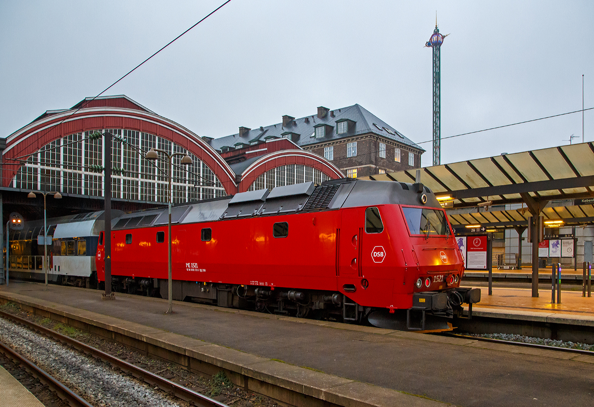 
Die DSB ME 1521 (92 86 0001 521-0 DK-DSB) steht am 22.03.2019, als Schublok mit einem Doppelstock-Regionalzug, im Hauptbahnhof Kopenhagen (Kbenhavns Hovedbanegrd) zur Abfahrt bereit.

Die Lok wurde 1983  von Thyssen-Henschel in Kassel unter der Fabriknummer 32634 gebaut, der Lokkasten ist von Scandia A/S in Randers und die elektrische Ausrstung von BBC (Brown, Boveri & Cie.).

Die Lokomotiven Baureihe ME (II) mit dieselelektrischer Leistungsbertragung bilden die neueste Baureihe von Diesellokomotiven fr den Streckendienst der Danske Statsbaner (DSB). In zwei Bauserien wurden insgesamt 37 Exemplare fr die DSB hergestellt.  Fnf technisch hnliche Maschinen gingen an die Norwegischen Staatsbahnen (NSB) als Baureihe Di.

Die Lokomotiven haben eine im unteren Bereich abgekantete Stirnfront mit einteiliger Frontscheibe, die Seitenwnde sind glatt und leicht bauchig, der Maschinenraum besitzt auf jeder Seite vier Fenster. Zwischen Dach und Seitenwand ist eine Dachschrge. Vorne haben die Lokomotiven ein groes Schneerumschild, an der Seite Blinkleuchten zur Anzeige der Abfahrbereitschaft. Die Lokomotiven sind mehrfachtraktions- und wendezugfhig

Die DSB interessierte sich in den 1970er Jahren fr Drehstromlokomotiven, bei denen sich der Dieselmotor ggf. gegen eine elektrische Anlage tauschen lie. So sollten die Maschinen bei einer spteren Elektrifizierung der Hauptstrecken weiterhin nutzbar bleiben. 1977 wurde in Dnemark die DB-Experimentallok 202 004 vom Typ DE 2500 erprobt, die sich trotz geringerer Nennleistung gegenber der Baureihe MZ I/II mit besseren Lauf- und Traktionseigenschaften auszeichnete. Die DSB orderte daraufhin 1979 die Baureihe ME, die in Kombination mit den Typen MY, MX, MZ und EA betrieben werden konnte. Als Hauptauftragnehmer trat Thyssen-Henschel in Kassel auf, die elektrische Ausrstung kam von BBC, die Dieselmotoren von GM und die Wagenksten wurden bei Scandia in Randers gebaut. Die Auslieferung der ersten MEs verzgerte sich, so dass Henschel 1981 fr einige Monate von der DB insgesamt 18 Loks der Reihe V 200 lieh, die von der DSB westlich des Groen Belts eingesetzt wurden. 

Die MEs wurden zunchst im IC- und Nahverkehr auf Seeland und Lolland-Falster sowie vor internationalen Gterzgen eingesetzt. Seit 1997 sind sie als einziger Dieselloktyp fr Reisezge auf der Store Blt- -Querung zugelassen.

TECHNISCHE DATEN:
Anzahl: 37
Hersteller: Thyssen-Henschel, Scandia , BBC
Spurweite: 1.435 mm (Normalspur)
Achsfolge: Co’Co’
Lnge ber Puffer : 21.000 mm 
Drehzapfenabstand: 11.550 mm
Achsabstand im Drehgestell:  2.000 + 1.850 mm
Hhe: 4.350 mm
Breite: 3.150 mm
Treibraddurchmesser: 	1.100 mm (neu)
Dienstgewicht: 115 t 	
Motor: EMD 16-645 E3B, 16-Zylinder-Zweitakt-Dieselmotor
Leistung: 2.426 kW (3.300 PS) bei 900 U/min
Anfahrzugkraft: 	360 kN
Anzahl der Fahrmotoren: 6 asynchrone Dreiphasen-Wechselstrommotore
Kraftbertragung: dieselelektrisch (Dieselmotor auf Generator, dieser liefert dann die elektrische Energie fr die 6 Fahrmotoren)	
Hchstgeschwindigkeit : 175 km/h 	
Kupplungstyp:  Schraubenkupplung
