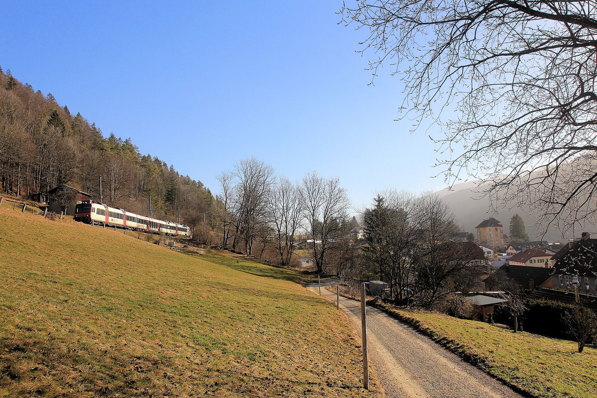 Die Eisenbahn im Vallon de St.Imier (Kanton Bern): Ein Domino-Zug oberhalb Sonvilier. Deutlich sichtbar der wegen des Sahara-Sands gelb gefärbte Himmel. 25.Februar 2021 