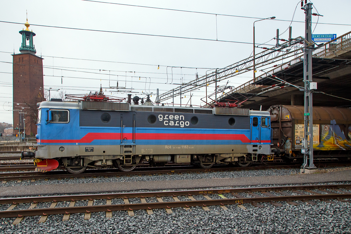 
Die Green Cargo  Rc4 1163 (91 74 000 1163-6 S-GC) fährt am 21.03.2019 mit einem Güterzug durch Stockholm Central.

Die Rc4 wurde 1976 von ASEA unter der Fabriknummer 1789 gebaut und an die SJ geliefert.

Die Baureihe SJ Rc ist eine für die schwedische Staatsbahnen Statens Järnvägar (SJ) von ASEA zwischen 1967 und 1988 gebaute Elektrolokomotive. ASEA (Allmänna Svenska Elektriska Aktiebolaget) war ein schwedisches Elektrotechnikunternehmen, 1988 legte der Konzern sein Geschäft mit der Schweizer BBC (Brown, Boveri & Cie) zur Asea Brown Boveri (ABB) mit Hauptsitz in Zürich zusammen.

Die Rc Lokomotiven waren die ersten thyristorgesteuerten Serien-E-Loks in Schweden. Mit 366 in verschiedenen Varianten (Rc1 bis Rc7, sowie Rm) hergestellten Exemplaren ist die Baureihe die in Schweden am meisten verbreitete Lokbaureihe. Der Vorgänger der Rc-Lokomotiven war eine umgebaute RB-Prototyplok. Vorteil der thyristorgesteuerten E-Loks ist der Einsatz von Gleichstrommotoren mit Stufenschalter und Diodengleichrichter, anstelle von Wechselstrommotoren. Ein Problem bei thyristorgesteuerten Rc-Lokomotiven besteht darin, dass sie starke Störungen im Fahrdrahtnetz verursachen.

Der Lokkasten ist eine geschweißte, selbsttragende Konstruktion. Die Seitenwände sind mit Sicken verstärkt, die durch vier runde Bullaugen und eine Türe unterbrochen werden, zur Dachkante hin sind die Lüftergitter angebracht. Im Maschinenraum befinden sich mittig das Thyristor- und Transformatorgerät – beiderseits von Baugruppenschränken für Antrieb und Elektronik umgeben. Als Antrieb wird ein ASEA-Antrieb, bei Rc1 bis 4 vom Typ LJH 108, verwendet. Der Kasten ruht auf einer geschweißten Stahlblechkonstruktion, die an den Fronten die Zug- und Stoßvorrichtung aufnimmt. Rahmen und Lokkasten ruhen auf einem Wiegebalken, der auf vier Schraubenfedern und auf je zwei zweiachsigen Drehgestellen liegt. Die Zugkraftübertragung erfolgt über zwischen Drehgestellen und Wiegebalken befindliche, diagonal angeordnete, Streben auf den Brückenrahmen.
Grundsätzlich können bis zu drei Rc-Loks (einschließlich der aus ihnen abgeleiteten Type Rm und El 16) über eine Vielfachsteuerung miteinander verbunden und von einem Führerstand aus bedient werden.

Die Varianten der Rc-Reihe:
        Baujahr       Stück   Gewicht     V-max        Zugkraft
Rc1 1967–1968      20       80,0 t     135 km/h      275 kN
Rc2 1969–1975    100       76,8 t     135 km/h      275 kN
Rc3 1970–1971      10       76,8 t     160 km/h      235 kN
Rc4 1975–1982    130       78,0 t     135 km/h      290 kN
Rc5 1982–1986      60       78,0 t     135 km/h      290 kN
Rc6 1985–1988      40       78,0 t     160 km/h      250 kN
Rm      1977              6       90,0 t     100 km/h      314 kN

Die Loks Rc6 1421 und 1422 erhielten zudem eine geänderte Getriebeübersetzung für Geschwindigkeiten bis 180 km/h und deshalb die Bezeichnung Rc7. Allerdings erwies es sich als zu kostspielig, die Reisezugwagen für die erhöhte Geschwindigkeit mit Magnetschienenbremsen und anderen Details auszurüsten. Daher wurden die Rc7 1421 (2004) und 1422 (2003) wieder zu Rc6 zurückgebaut, behielten jedoch ihren dunkelblauen Anstrich.

TECHNISCHE DATEN der Rc4:
Spurweite:  1.435 mm (Normalspur)
Achsformel: Bo'Bo'
Länge über Kupplung: 15.500 mm
Drehzapfenabstand: 7.700 mm
Treibraddurchmesser:  1.300 mm 
Gewicht: 76 t
Höchstgeschwindigkeit: 135 km/h
Leistung: 3.600 kW
Anfahrzugkraft: 290 kN
Stromsystem: 15 kV 16 2/3 Hz ~