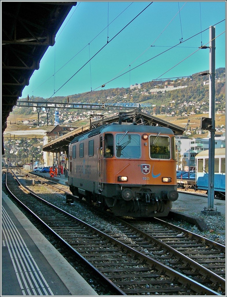 Die im Interregio-Cargo Farbkleid gehaltene Re 4/4 II 11320 in Vevey, links im Bild ein B-C Neuzugang.
12. Nov. 2013