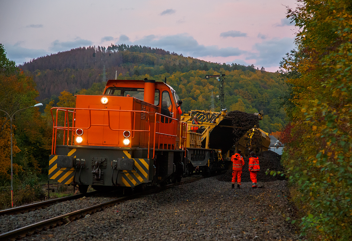 
Die KSW 45 (98 80 0276 016-9 D-KSW) eine MaK G 1204 BB der Kreisbahn Siegen-Wittgenstein mit den zwei Materialförder- und Siloeinheiten MFS 100 am 21.10.2020 in Herdorf. Hier beim Einfahrtsignal werden die mit Altschotter gefüllten MSF 100 entleert. Der von der Plasser & Theurer Gleisschotter-Bettungsreinigungsmaschine RM 95-800 W der MGW angefallene Altschotter wird dann später von einem Bagger auf einen Kippwagen-Zug (MK 45 DH „LW-Kipper“) verladen und abgefahren.

Die Bettungsreinigungsmaschine bereitet den Gleisschotter wieder auf, dabei werden die Schottersteine wieder kantig gemacht und gewaschen. Aber auch ein großer Teil wird ausgesondert und ist für den Bahnbau nicht mehr verwendbar. Der Schotter muss eine gewisse Größe haben und kantig sein.

Nach entsprechender Aufbereitung, gibt es aber für den alten Schotter sicherlich noch genügende Einsatzgebiete.  
