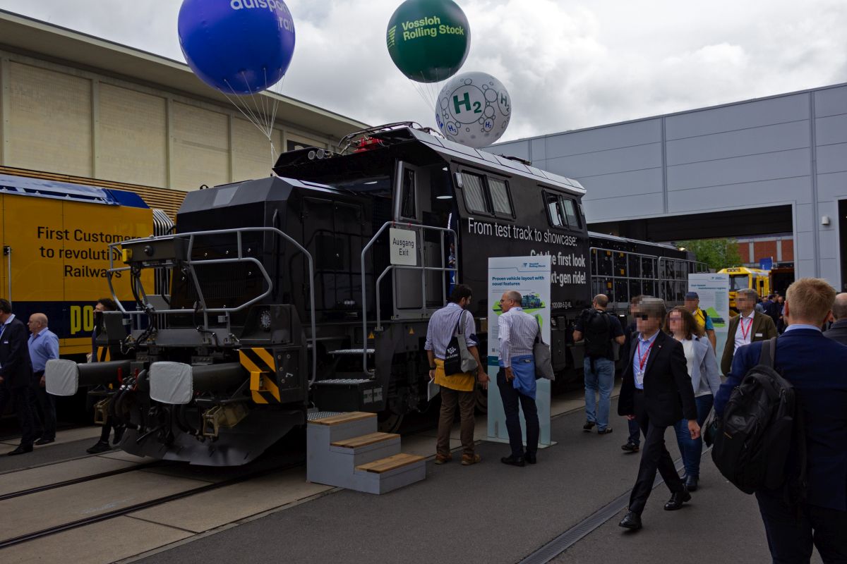 Die meisten Lokomotiven, die auf der InnoTrans 2024 ausgestellt waren, verf�gen �ber verschiedene M�glichkeiten f�r einen emissionsfreien Betrieb. 1120 001, die auf den ersten Blick wie eine klassische Diesellok mit Mittelf�hrerstand aussieht, verf�gt �ber einen Elektromotor, der aus einer Oberleitung oder einem Akkumulator versorgt werden kann. Die Lok geh�rt zum Typ Vossloh Modula, wobei Vossloh nur noch ein Markenname ist. Das Werk in Kiel geh�rt mittlerweile dem chinesischen Konzern CRRC.