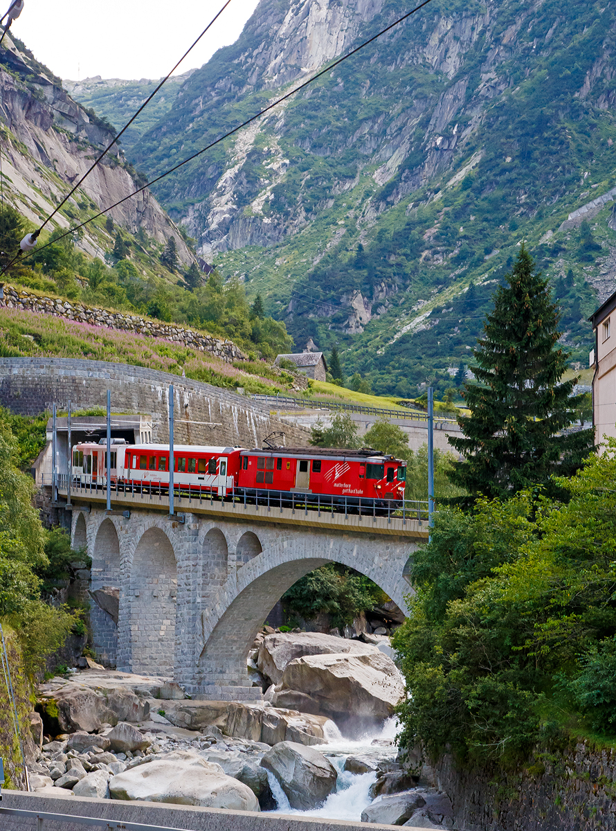 Die MGB Deh 4/4 – 55 „Brig“ kommt am 01.08.2019 von Andermatt nach Gschenen hinab und berquert hier die Reuss. 

Die Strecke Gschenen–Andermatt ist die Schllenenbahn, eine einspurige Zahnradbahn (Zahnstangensystem Abt) im Schweizer Kanton Uri. Sie durchquert die Schllenenschlucht der Reuss und weist eine Maximalsteigung von 179 Promille auf. Die Bahnstrecke wurde zwischen 1913 und 1917 durch die Schllenenbahn AG (SchB) gebaut. Die Schllenenbahn AG fusionierte 1961 mit der Furka-Oberalp-Bahn (FO), welche wiederum  zum 1. Januar 2003 mit der Zermatt-Bahn (BVZ), zur heutigen Matterhorn-Gotthard-Bahn (MG) fusionierte. 

Heute befrdert die Schllenenbahn im Jahr ca. 400.000 Reisende. Sie hatte in der Vergangenheit auch eine groe militrische Bedeutung. Sie versorgte die Festungsanlagen des Rduit im Gotthardmassiv. Die Bahnstrecke hat eine Gesamtlnge von 3.770 Metern, davon sind 2.509 mit Zahnstange ausgerstet. 1.022 Meter der Strecke befinden sich in Tunneln und 1.110 Meter in Galerien. Die Bahn fhrt durch fnf Tunnel und fnf schtzende Galerien. Vier Mal fhrt die meterspurige Schmalspurbahn ber eine Brcke.

Auf der Schllenenbahn wurden ursprnglich vier zweiachsige Elektrolokomotiven fr kombinierten Adhsions- und Zahnradbetrieb von SLM und BBC mit Bezeichnung SchB HGe 2/2 eingesetzt. Ursprnglich liefen sie mit 1.200 Volt Gleichstrom. 1941 wurden sie auf 11.000 Volt Wechselstrom umgestellt. Die letzte dieser vier Lokomotiven wurde 1985 Spter kamen kamen FO BCFhe 2/4 der Schweizerischen Lokomotiv- und Maschinenfabrik mit einem Antrieb der BBC zum Einsatz. ausrangiert. Heute (2019) befahren Deh 4/4 und Wagen der Matterhorn-Gotthard-Bahn die Strecke. Dabei befindet sich das Triebfahrzeug stets am talseitigen Ende, am Zugschluss luft ein Steuerwagen.
Die Schllenenbahn bietet einen stndlichen Pendelverkehr an und ist in den Fahrplan der SBB und der Matterhorn-Gotthard-Bahn vollstndig integriert.
