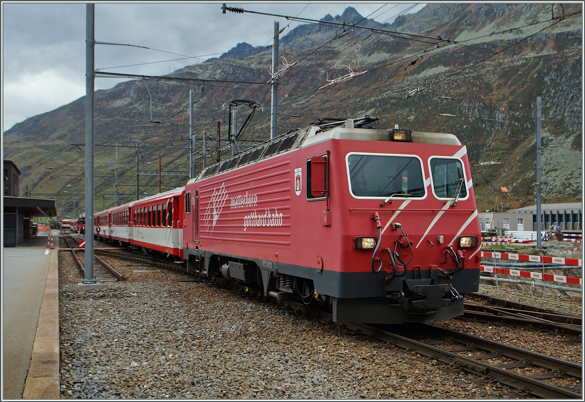Die MGB HGe 4/4 103 mit einem Regionalzug nach Disentis im zur Zeit durch Umbauarabeiten etwas eingeschränkt zu benutzenden Bahnhofs von Andermattt .
10. Okt. 2014