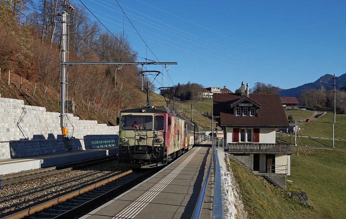 Die MOB GDe 4/4 6006  Aigle les Murailles  (ex GFM/TPF GDe 4/4 102) fährt mit dem MOB Golden Pass Panoramic PE 2111 durch den Bahnhof von Les Sciernes. Der Zug besteht aus den Wagen Bs 222, Bs 234, Bs 233 und BDS 224, wobei der Schlusswagen entgegen seiner Bezeichnung über 1. Klasse Sitze verfügt.

26. November 2020 