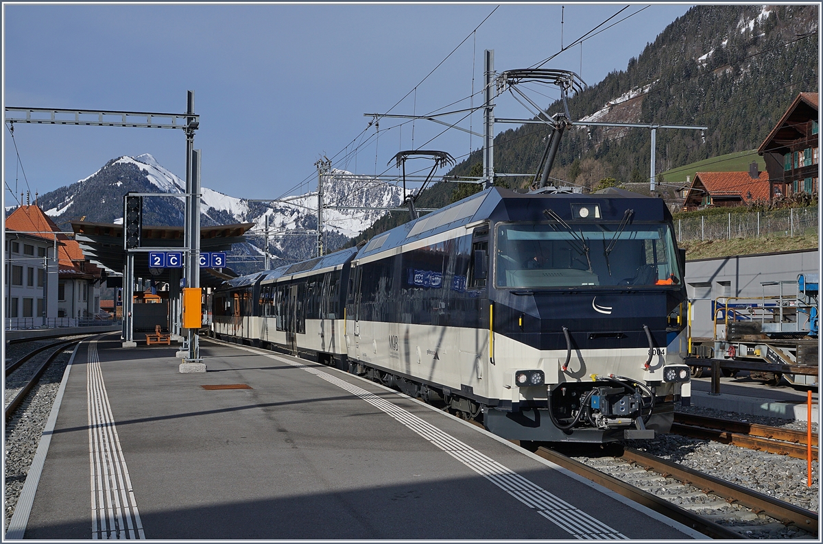 Die MOB Ge 4/4 8004 wartet mit ihrem Regionalzug in Château d'Oex auf die Abfahrt Richtung Zweisimmen. 
2. April 2018