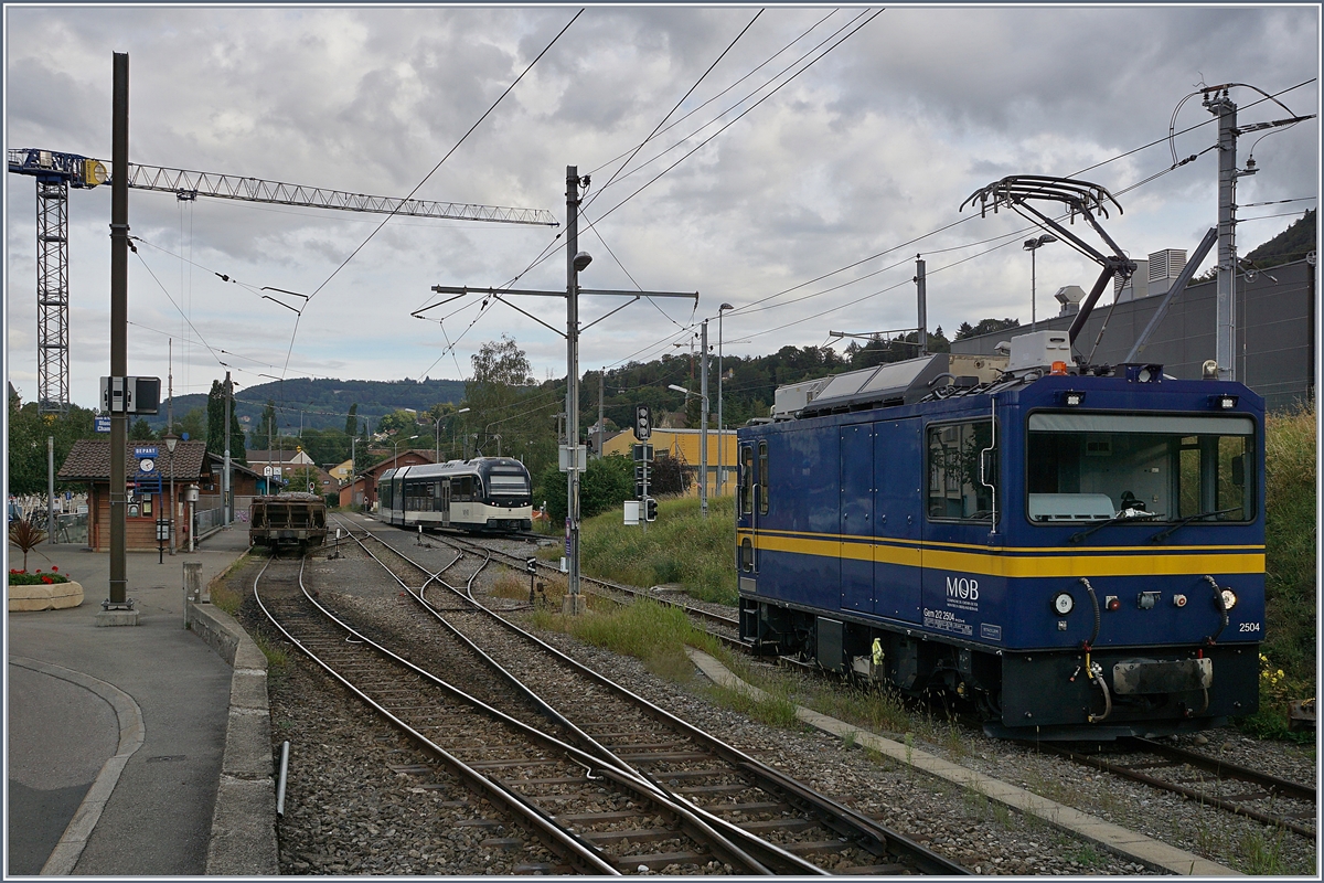 Die MOB Gem 2/2 2504 wartet in Blonay auf einen neuen Einsatz, während im Hintergrund ein MVR ABeh 2/6 von Les Pléiades kommend einfährt.

26. Aug. 2020