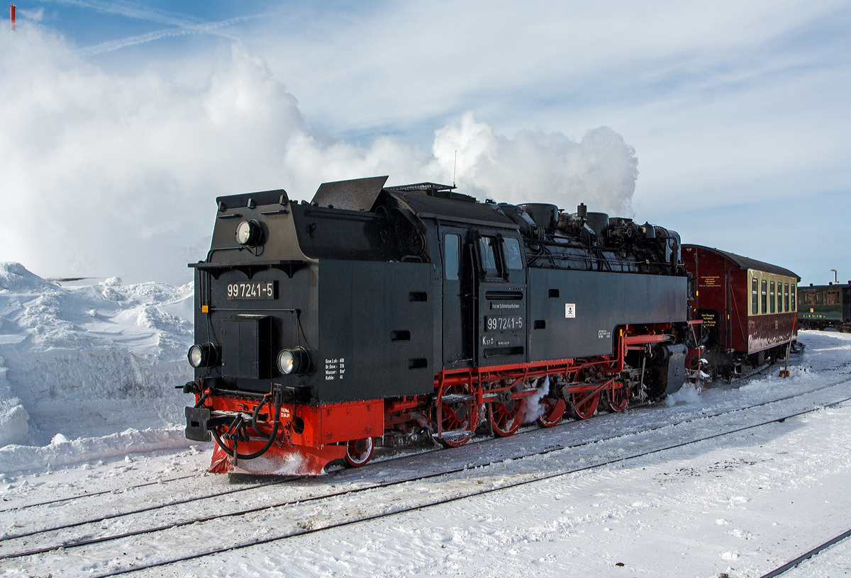 Die Neubau-Dampfloks der HSB - Harzer Schmalspurbahnen 99 7241-5 (ex DR 099 151-3, 99 0241-2, 99 241) stehen am 23.03.2013 auf dem Bahnhof Brocken (1.125 m ü.NN) zu Talfahrt bereit. 

Den mächtigen See sieht man ja, aber nicht die Minus 17 Grad Kälte und bei dem starken Wind waren es gefühlte 30 Grad Minus. Links oben sieht man die Spitze vom Brockenturm.

Die Meterspurige Dampflok wurde 1956 bei LKM (VEB Lokomotivbau Karl Marx Babelsberg unter der Fabriknummer 134018 gebaut und als DR 99 241 an die Deutsche Reichsbahn geliefert. Zum 01.07.1970 erfolgte die Umzeichnung in DR 99 7241-5, nachdem man sie 1979 auf Ölfeuerung umbaute wurde sie als DR 99 0241-2 bezeichnet. Da die Ölfeuerung nicht zum Vorteil der Maschinen war und Öl in der DDR knapp war wurde sie (wie alle Loks) 1983 wieder auf Kohlefeuerung zurück gebaut und nun wieder als DR 99 7241-5 bezeichnet. Ab dem 01.01.1992 wurden die Lok noch als DR 099 151-3 um bezeichnet, bis am 01.02.1993 in die HSB überging, welche dann wieder die alte DR-Bezeichnungen verwendete.

Diese Neubau-Dampfloks der  Bauart 1'E1' h2t / Gattung K 57.10 werden als Baureihe 99.23–24 geführt (und nicht fälschlicherweise als 99.72, diese hätte eine Spurweite von 750 mm).  Wie man an der Bauart und Gattung sehen kann haben sie 7 Achsen, 5 davon sind angetrieben und je eine Laufachse befindet sich vor und hinter den Triebachsen.  Die Radsatzfahrmasse beträgt 9,5 t.

Weitere Technische Daten:
Spurweite: 1.000 mm (Meterspur) 
Länge über Puffer: 12.500 mm
Höhe:  3.650 mm
Breite:  2.645 mm
Fester Radstand:  4.800 mm
Gesamtradstand:  8.700 mm (1.950 / 4x1.200 / 1.950)
Kesselüberdruck : 14 bar
Leistung: 515 kW (700 PS)
Höchstgeschwindigkeit: 40 km/h (Vor- und Rückwärts)
Eigengewicht: 47.5 t
Dienstgewicht: 64,5 t (bei vollen Vorräten)
Kohlevorrat: 4,0 t
Wasservorrat: 8 m³
Anfahrzugkraft:  102,9 kN (10,5 Mp)
Treibraddurchmesser:  1000 mm
Laufraddurchmesser:  550 mm
