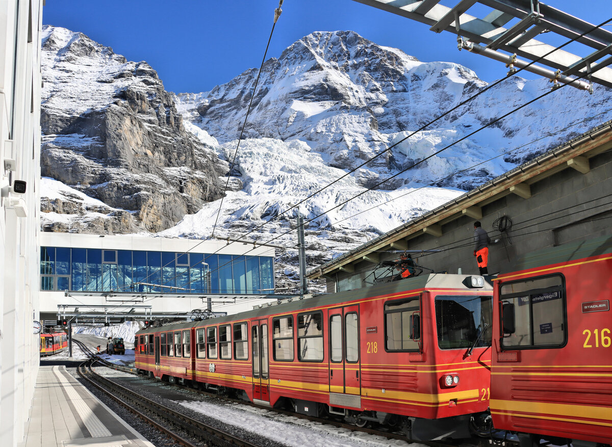 Die  neue  Jungfraubahn: Die beiden Doppeltriebwagen 216-218 pendeln von Eigergletscher zur Kleinen Scheidegg, während im Hintergrund der dreiteilige Triebwagen 223 aus dem neuen Bahnhof ausfährt Richtung Jungfraujoch. Der Gletscher ist im Vergleich zum Bild von 1975 erheblich zurückgegangen. 14.Oktober 2021 