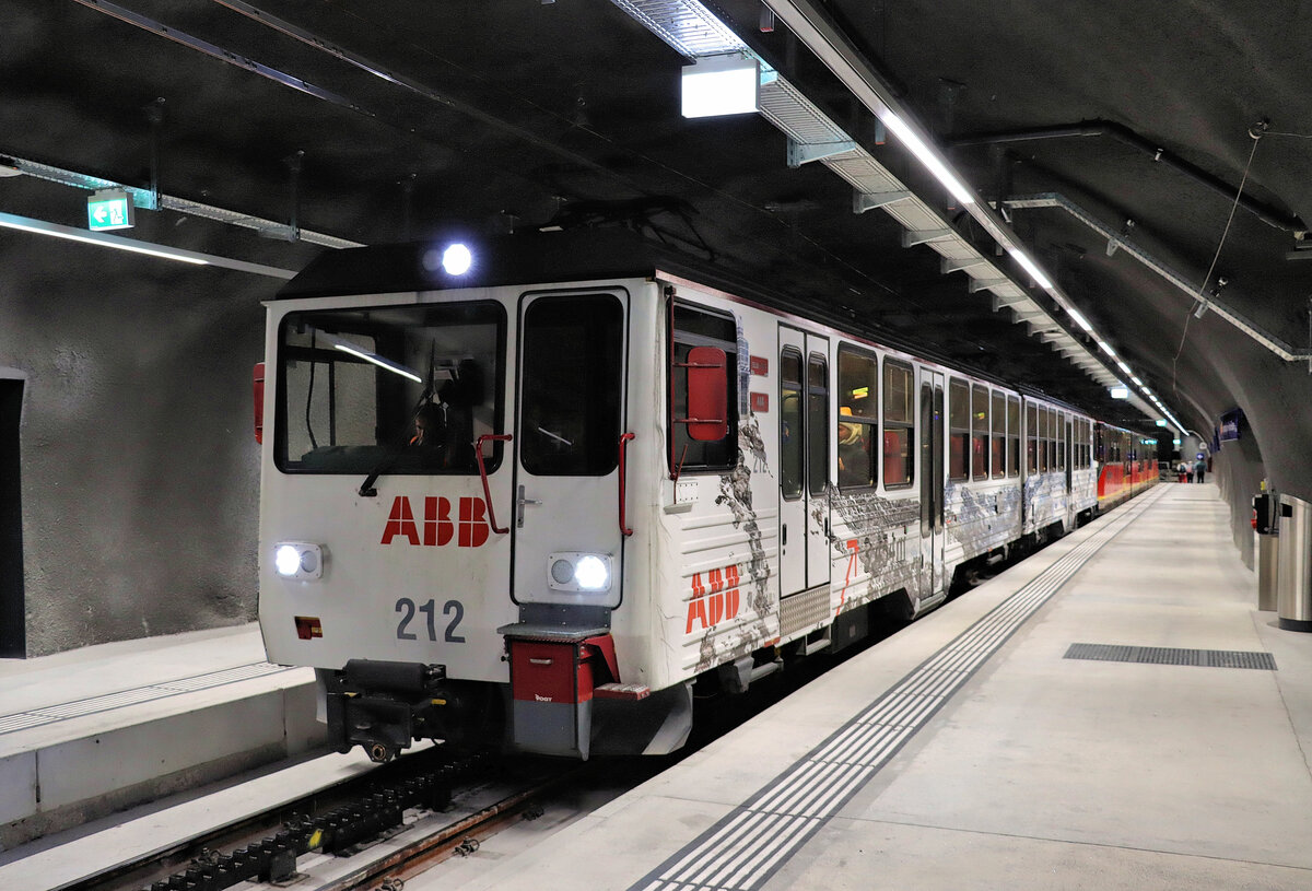 Die  neue  Jungfraubahn: In der Endstation Jungfraujoch steht ein Zug bestehend aus Doppeltriebwagen BDhe4/8 212 + dreiteiligem Triebzug Bhe4/8 223 + Systempaletten-Tragwagen Kkl 23. Die Endstation Jungfraujoch besteht heute aus zwei separaten Röhren mit je einem Gleis. 14.Oktober 2021 