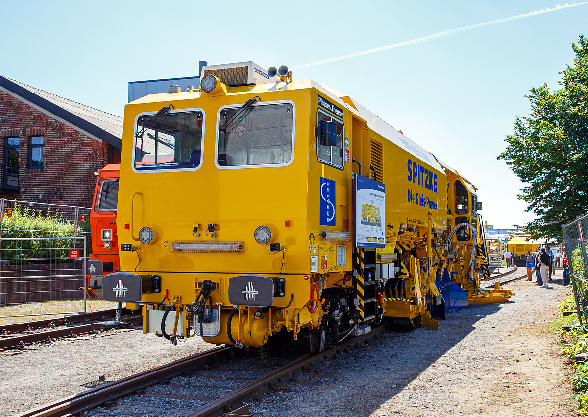 
Die neue Plasser & Theurer Schotterverteil- und Planiermaschine USP 4000 SWS, Schweres Nebenfahrzeug-Nr. D-SPAG 99 80 91 25 012-1, der SPITZKE SE, präsentiert auf der iaf 2017 in Münster (hier am 01.06.2017).

Die USP 4000 SWS wurde 2017 von Plasser & Theurer in Linz (A) unter der Maschinen Nr. 6723 gebaut.

Die Schotterverteil- und Planiermaschine USP 4000 SWS stellt das perfekte Schotterbett von Gleisen und Weichen in nur einem Arbeitsdurchgang her. Das „One-Pass-Verfahren“ soll die Verteilung und Planierung des Schotters in einem Arbeitsgang ermöglichen. Die neue Anordnung der Aggregate ermöglicht, dass der aufgekehrte Schotter direkt vor die Arbeitsorgane oder durch die vier Entladeöffnungen des Bodenförderbands an jeder gewünschten Stelle im Bereich der Stopfzonen ausgegeben werden kann.

In der „Technischen Spezifikation für die Interoperabilität zum Teilsystem Fahrzeuge – Lärm“ (TSI Noise 2015) wurden für neue Schienenfahrzeuge europaweit einheitliche Grenzwerte festgelegt. Die Schotterverteil- und Planiermaschine USP 4000 SWS gehört zu den ersten Maschinen, die diese Vorgaben erfüllt, und markiert deshalb einen neuen Standard. 

Bei der USP 4000 SWS sind alle Aggregate so angeordnet, dass technologisch richtiges Arbeiten möglich ist und die Verteilung und Planierung des Schotters in einem Arbeitsgang erfolgen kann. Durch das Bodenförderband und die Verteilschächte im vorderen Teil der Maschine kann sie auch für punktuelle Einschotterungen eingesetzt werden. 

Entscheidend bei allen Einsätzen ist das neue Design mit zwei Kabinen, das uneingeschränkte UIC-Sicht in beide Fahrtrichtungen gewährleistet. Bei Überstellfahrten lässt sich die USP 4000 SWS nun wie das Schotterbewirtschaftungssystem BDS vorwärts- und rückwärtsfahren. 

Besonderes Augenmerk wurde bei der Konstruktion auf den Schutz vor Lärm und Staub gelegt. So erhielt die Kehranlage für Gleise und Weichen eine spezielle Gummiauskleidung, die sowohl den Lärm als auch den Verschleiß reduziert. Das Schottersilo mit einem Fassungsvermögen von 5 m³ ist mit ROBALON-Kunststoffplatten ausgekleidet. Eine Staubniedernebelungsanlage reduziert die Staubemissionen im gesamten Arbeitsumfeld.
Bei leerem Silo erfüllt die Maschine auch die Anforderungen der Streckenklasse C2. Im Rahmen der iaf 2017 wurde diese neue USP 4000 SWS der Firma Spitzke übergeben, als topaktuelle Ergänzung für die leistungsfähige Instandhaltungsflotte.  

TECHNISCHE DATEN:
Spurweite: 1.435 mm
Achsanzahl: 4
Länge über Puffer: 19.140 mm
Drehzapfenabstand: 11.500 mm
Achsabstand im Drehgestell: 1.800 mm
Eigengewicht: 64 t
Motorleistung: 470 kW
Max. Geschwindigkeit geschleppt:  90 km/h
Max. Geschwindigkeit Eigenantrieb: 100 km/h
Min. Kurvenradius: 120 m

Leistungsparameter:
Arbeitsleistung bei Durcharbeitung des Gleises: max. 1.800 m/h
Arbeitsleistung bei Umbau des Gleises: max. 1.400 m/h
Arbeitsradius: ≥ 150 m
Arbeiten in Überhöhung: max. 180 mm