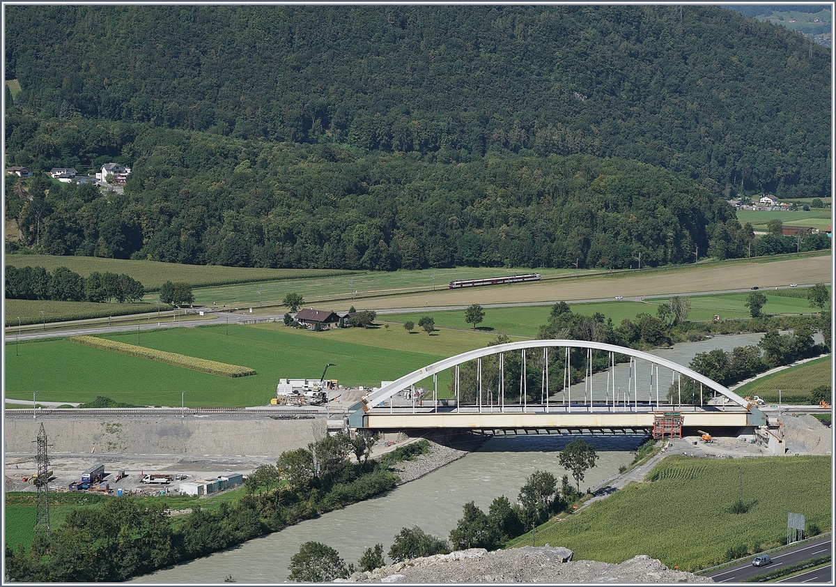Die neue Rhonebrücke der Strecke von Brig nach Lausanne im Vordergrund, und im Hintgergrund ein Walliser Domino auf dem Weg Richtung Monthey auf der Strecke von St-Maurice nach St-Gingolph.
26. August 2016