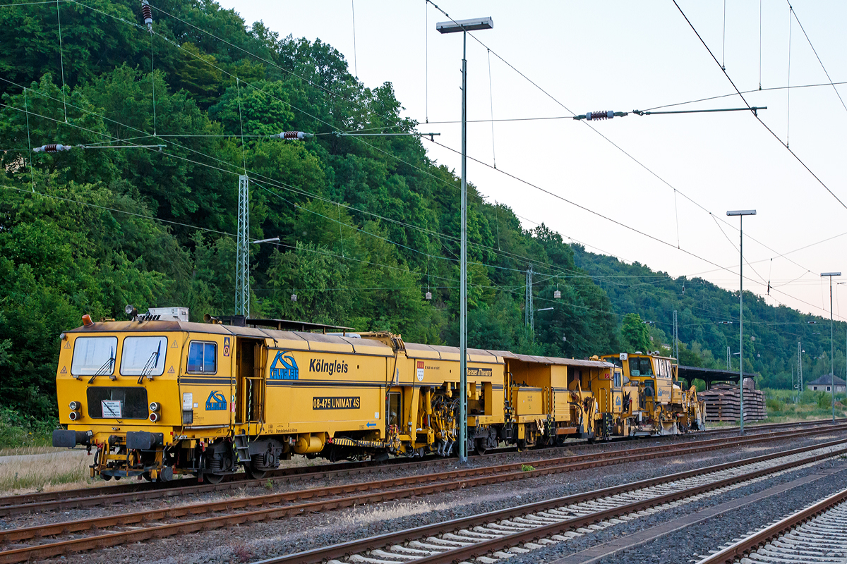 
Die Plasser und Theurer Universalstopfmaschine 08-475 Unimat 4S (Schweres Nebenfahrzeug Nr. 99 80 9424 005-3 D-KG, ex 97 43 42 522 17-0) und dahinter die Plasser und Theurer Schnellschotterplaniermaschine SSP 110 SW (Schweres Nebenfahrzeug Nr. 99 80 9425 026-8 D-KG), beide der Klngleis, abgestelt in Dillenburg, aufgenommen am frhen Morgen (5:19 Uhr) des 01.07.2015. Die SPITZKE AG hat ein 60-prozentige Beteiligung an der KLNGLEIS Gleisbau GmbH & Co. KG.