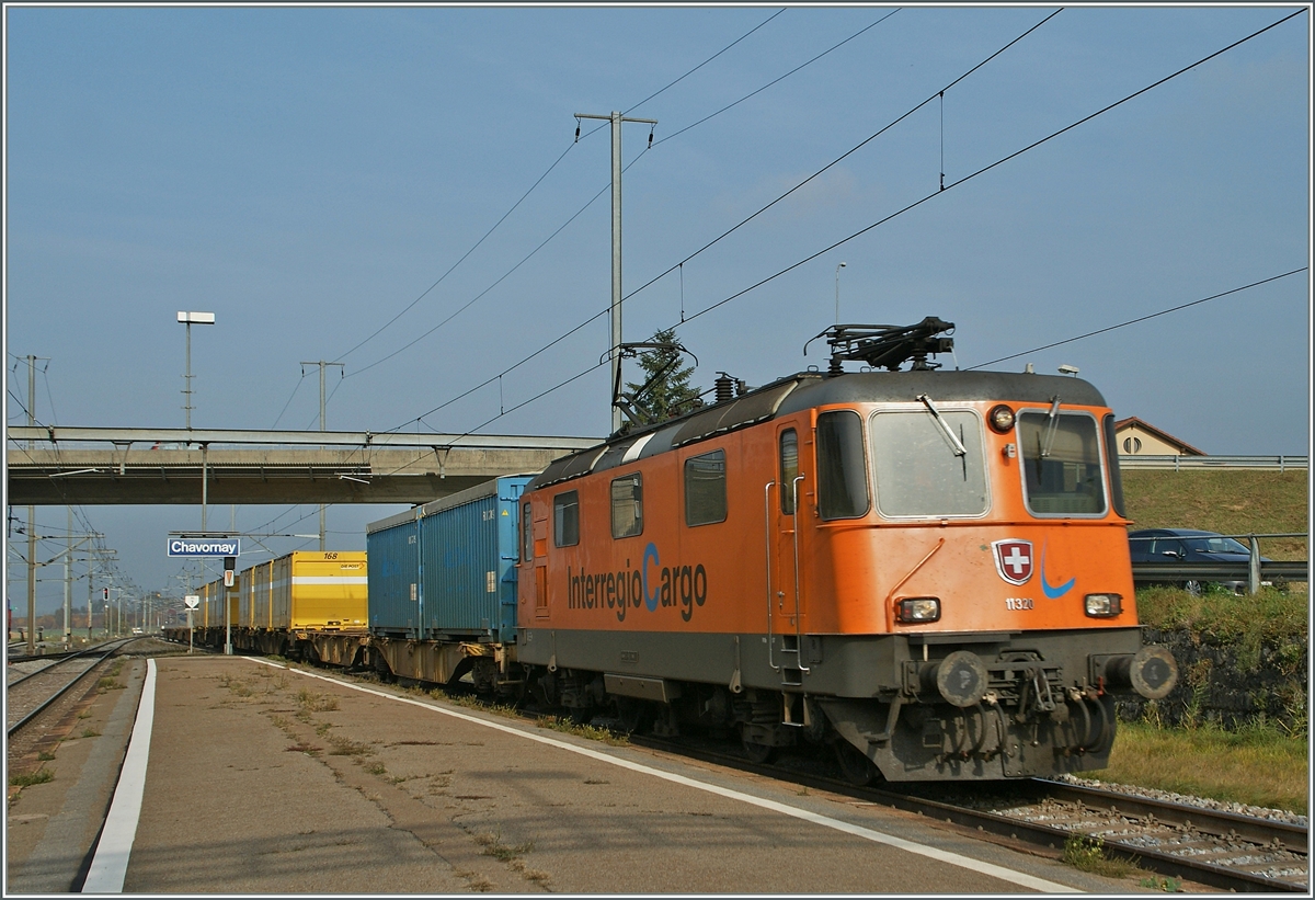 Die Re 4/4 II 11320 in der  Interregio Cargo  Lackierung mit einem Postzug nach Daillens bei der Durchfahrt in Charonay.
31. Okt. 2011