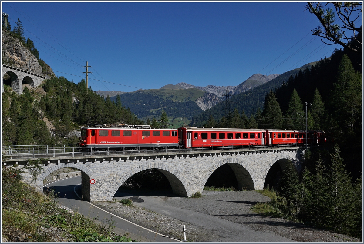 Die RhB Ge 6/6 II 707 befährt mit ihrem Albulaschnellzug kurz nach Muot den Albulaviaduk I und wird gleich in den 1598 m langen Rugnux Kehrtunnel fahren.
