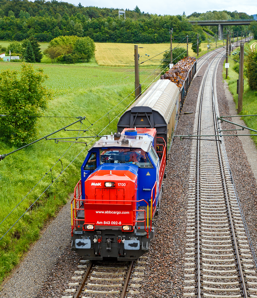 
Die SBB Cargo Am 843 092-8 (eine modifizierte Vossloh MaK 1700) fhrt am 17.06.2016 mit einem kurzen Gterzug durch Bietingen in Richtung Schaffhausen. 

Einen lieben Gru an den freundlichen Lokfhrer zurck.

Die Lok wurde 2005 von Vossloh in Kiel unter der Fabriknummer 1001440 gebaut und an die SBB Cargo AG in Basel geliefert. Sie gehrt zu den letzten fnf Loks der Serie an die SBB Cargo, diese fnf Maschinen (Am 843 091 bis 095) sind zustzlich mit der deutschen Zugsicherung Indusi ausgerstet worden und haben einen zweiten Fhrerstand auf der rechten Seite. 

Die SBB Am 843 ist eine moderne Rangier- und Gterzugslokomotive der Schweizerischen Bundesbahnen (SBB). Sie ersetzt ltere Rangierlokomotiven wie die SBB Bm 4/4 und SBB Bm 6/6. Eingesetzt wird die Am 843 von der Division Infrastruktur (843 001ff), der Division Personenverkehr (041ff) und von SBB Cargo (050ff). Die Division Infrastruktur verwendet die Am 843 vor allem in den grossen Rangierbahnhfen, Personenverkehr in Basel und Chiasso und bei SBB Cargo dient sie vor allem fr Zustellfahrten im Nahgterverkehr.

Die Am 843 verfgt ber einen Mikropartikelfilter und gilt als eine der saubersten Diesellokomotiven. Die Filteranlage verhindert, dass 95 % der Russpartikel in die Umwelt abgegeben werden. Die Am 843 basiert auf den dieselhydraulischen Standardlokomotiven des Typs G 1700-2 BB des Kieler Schienenfahrzeugherstellers Vossloh, ist aber im Gegensatz zur Standard-Version auf den in der Schweiz blichen Linksverkehr ausgelegt.

Anfang der 2000ter musste eine neue Lokomotive angeschafft werden, welche allen Anforderungen gerecht wurde. So musste die Lok ber hervorragende Langsam Fahreigenschaften verfgen um im Verschubdienst eingesetzt werden zu knnen. Die SBB-Cargo wollte aber auch im Nahbereich Zustellfahrten machen, was eine Hchstgeschwindigkeit von 100 km/h erfordernde und gute Leistung. Schlielich fiel die Wahl auf die MaK 1700 BB, welches bei Vossloh in Kiel entstehen sollte. Vossloh entstand aus der ehemaligen und bekannten Unternehmen Maschinenfabrik Kiel (MaK). Dies war die erste grere Serie die der Kieler Lokomotivbau in die Schweiz verkaufen konnte. Noch bei der letzten Ausschreibung haben die Kieler gegen das Konsortium um Alstom verloren. Ebenfalls eine Neuheit war, dass die SBB erstmals eine grere Anzahl dieselhydraulischer Lokomotiven anschafften, nachdem bei der Am 841 noch einer dieselelektrischen Lokomotive der Vorzug gewhrt wurde.

Der Lokrahmen besteht aus Walztrgern und massiven Blechen, welche in Schweikonstruktion miteinander verbunden wurden. Dadurch entsteht ein stabiler und robuster Grundaufbau, welcher der Lok die notwendigen Festigkeiten verleiht. Im Lokrahmen wurde eine so genannte Umweltwanne montiert, welche aus dem Fahrmotor austretenden Flssigkeiten (Minerallen und Wasseremulsionen) auffngt, diese knnen mit Hilfe eines Ablasshahnes entleert und fachmnnisch entsorgt werden.

Der vordere lngere Vorbau beinhaltet neben dem Dieselmotor auch die notwendige Khlanlage und das Antriebsgetriebe. Der krzere hintere Vorbau enthlt neben der Druckluftanlage auch die elektrischen Komponenten wie die Batterieladung.

Zwischen den beiden Vorbauten befindet sich das Mittelfhrerhaus, welches ber die zwei diagonal gegenberliegenden Eingangstren betreten werden kann. In ihm sind alle fr den Lokfhrer notwendigen Einbauten vorhanden. Ein Fhrersitz je Fahrpult und Fahrrichtung, welcher mit Arm- und Rckenlehnen ausgerstet ist, erlaubt die sitzende Bedienung der Lokomotive. Dieser Fhrersitz ist drehbar gelagert und kann zusammengeklappt und unter den Fhrertisch verschoben werden. Dadurch ist auch die stehende Bedienung der Lokomotive ohne Behinderung mglich. Zur Entlastung der Fe sind auch verstellbare Fusttzen montiert. Der Fuboden ist mit einem Profilgummibelag belegt worden, der eine einfache Reinigung und dennoch einen guten Stand erlaubt.

Angetrieben wird die Lokomotive von einem 12-Zylinder-4Takt-Dieselmotor vom Typ Caterpillar 3512 B DI-TA-SCAC, dieser erbringt mit Hilfe der beiden Abgasturbolader und der Ladeluftkhlung eine maximale Leistung von 1.500 KW (2.040 PS). Seine hchste Drehzahl betrgt 1.800 U/min. Er wird mit Hilfe eines elektrischen Anlassers gestartet und ist elektronisch geregelt. Dadurch ist es mglich, den Motor bestmglich im optimalen Leistungsbereich zu betreiben. Sein Gewicht betrgt mit 322 Liter Schmierl und 134 Liter Khlwasser 7.700 kg.

Die vom Dieselmotor erzeugte Leistung wird mittels einer Gelenkwelle auf das hydrodynamische Getriebe (Turbowendegetriebe), vom Typ Voith L5r4zseU2, bertragen. Das Getriebe hat eine maximale Leistung von 1.400 kW. Es beschrnkt somit die Leistung der Lokomotive und verhindert zugleich, dass der Fahrmotor berlastet werden kann. Seine maximale Drehzahl ist gleich gro, wie jene des Fahrmotors. 

Das Turbowendegetriebe besitzt fr jede Fahrrichtung zwei Drehmomentwandler. Dem eigentlichen Wandlergetriebe ist eine mechanische Getriebe nachgeschaltet, das eine niedrige fr den Rangierbetrieb bestimmte Schaltung und eine hhere fr den Streckenbetrieb bestimmte Schaltung zur Verfgung zu stellen. Diese Umschaltung darf jedoch erst im Stillstand erfolgen.

Die Achsen in den Drehgestellen werden ber Gelenkwellen vom Turbowendegetriebe angetrieben. Die bertragung auf die Achsen erfolgt mit Hilfe von Stirnradgetrieben mit Kegelradvorgelege.

Technische Daten:
Spurweite: 1.435 mm (Normalspur)
Achsformel: B'B'
Lnge ber Puffer: 15.200 mm
Hhe: 4.220 mm
Breite: 3.080 mm
Drehzapfenabstand: 7.700 mm
Achsstand im Drehgestell: 2.400 mm
Dienstgewicht:  80 t
Hchstgeschwindigkeit: 100 km/h (40 km im Rangiergang)
Installierte Leistung: 1.500 kW (2.040 PS)
Anfahrzugkraft:  249 kN
Treibraddurchmesser:  1.000 mm
Motorentyp:  Caterpillar 3512B DI-TA-SCAC
Nenndrehzahl: 1.800/min
Kleinster bef. Halbmesser:  60 m
Tankinhalt: 3.500 l