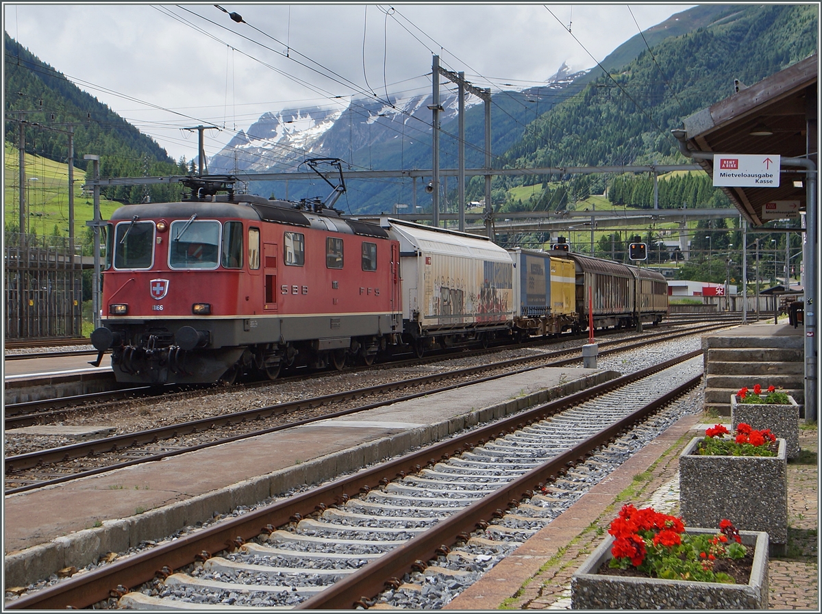 Die SBB RE 4/4 II 11166 mit einem kurzen Güterzug in Airolo. 
(Gotthrad-Südrampe). 
23. Juni 2015