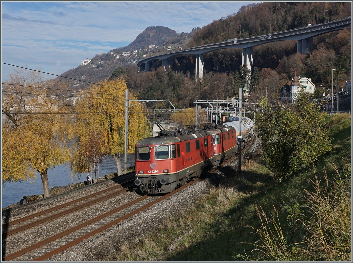 Die SBB Re 4/4 II 11332 (Re 420 332-0) und eine weitere sind mit einem Güterzug in Richtung Wallis kurz vor Villeneuve unterwegs und passieren ein paar wenige, noch mit mit bunten Blätter geschmückte Bäume am Ufer des Genfer Sees.

23. November 2020