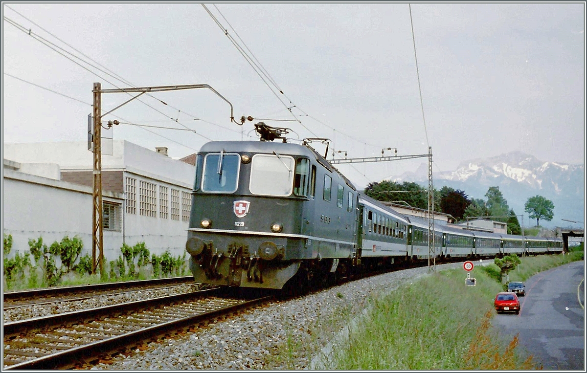 Die SBB Re 4/4 II 11219 ist kurz nach Vevey mit einem Schnellzug in Richtung Lausanne unterwegs. Das besondere an diesem qualitativ nicht sonderlich guten Analog Bild ist weniger der Zug, als die damals noch vorhandene alte Fahrleitungsanlage, die sich nicht nur durch Langlebigkeit sondern auch durch ihre filigrane Art auszeichnete. 

im März 1995
