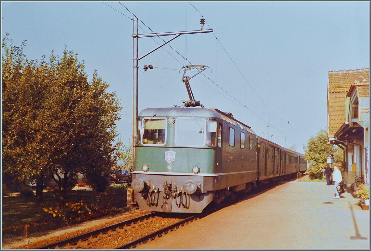 Die SBB Re 4/4 II 11140 erreicht den Halt Rüti bei Büren mit ihrem Regionalzug von Herzogenbuchsee nach Lyss.

Die Strecke von (damals) Neu Solothurn nach Busswil wurde am 4. Dezember 1876 eröffnet und am 3. Oktober 1944 elektrifiziert. 1994 wurde der Personenverkehr auf dem Abschnitt Solothurn - Büren an der Aare eingestellt, für das Tanklager  Thomen  verkehren weiterhin  Zustellfahren doch die Zeitweilig verkehrenden Dampfzüge von Solothurn nach Büren a/A mussten 2016 infolge einer maroden Brücke bei Büren eingestellt werden. 

Ein Analogbild vom Oktober 1984