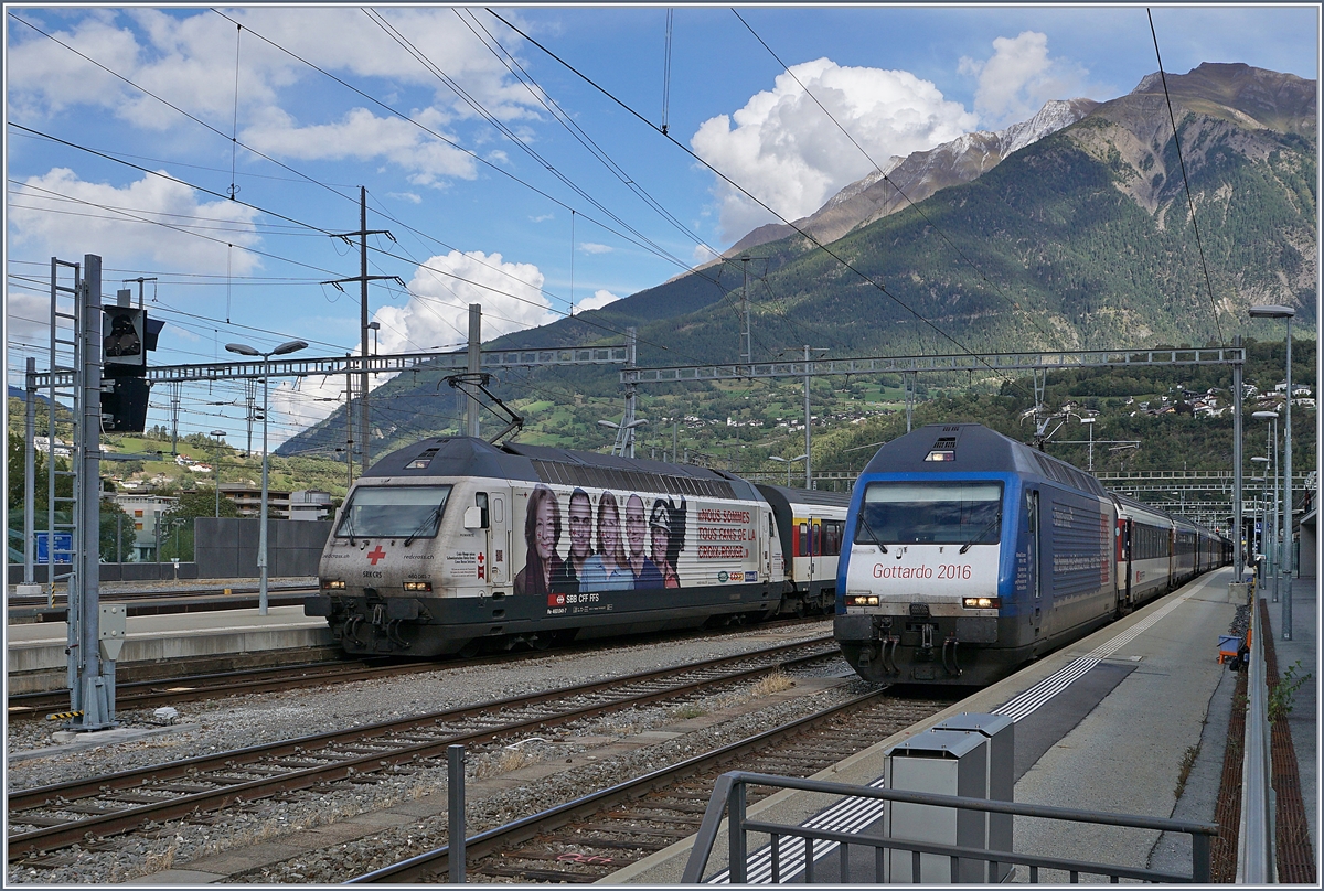 Die SBB Re 460 041-7  Rotes Kreuz  und die Re 460 079-7  Gotthard 2016  warten mit ihren Zügen nach Romanshorn und Genève-Aéroport in Brig auf die Abfahrt.
18.Sept. 2017