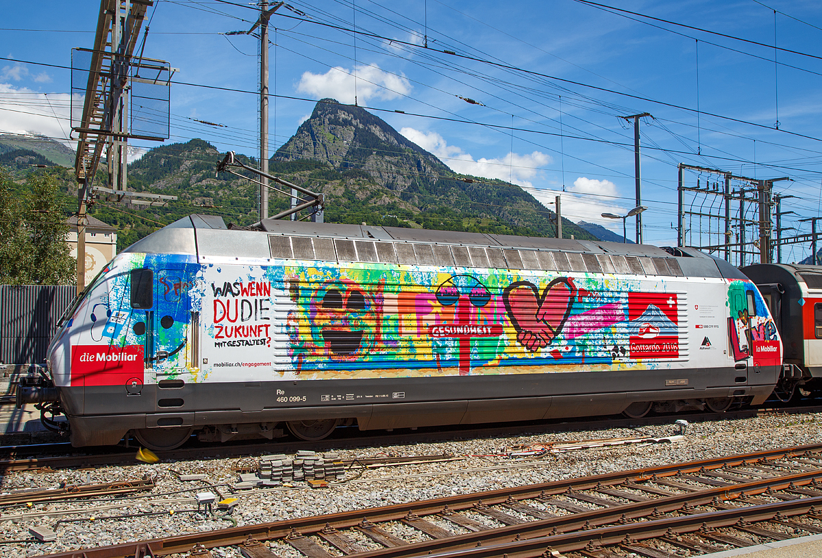 
Die SBB Re 460 099-5 „ Bodensee , Werbelok für die Mobiliar und Gottardo 2016,  am 20.06.2016 im Bahnhof Brig.

Die Lok2000 wurde 1994 von der SLM unter der Fabriknummer 5666 gebaut, der elektrische Teil ist von ABB.

Nun auch mal eine ausführliche Beschreibung zu diesem  Loktyp: 
Die SBB bestellte im Zusammenhang mit den Projekten Bahn 2000 eine erste Serie von 12 Universal-Hochgeschwindigkeitslokomotiven, noch als Re 4/4VI – 10701 bis 10712 bestellt. Diese Bestellung wurde noch vor Beginn der Konstruktionsarbeiten auf 24 erhöht. Für den alpenquerenden Güterverkehr wurde von der Eidgenossenschaft eine weitere Serie von 75 Lokomotiven (auch als 'Hupac'-Lokomotiven bekannt) in Auftrag gegeben. Die vorgegebenen Liefertermine für dieses Los waren derart kurz, dass die SLM an die Kapazitätsgrenze ihrer Werkstätte gelangte. Es wurden deshalb dreißig Lokkasten an Krauss-Maffei in München untervergeben 

Im Hinblick auf die geplante Hochgeschwindigkeitsstrecke wurden nochmals zwanzig Lokomotiven nachbestellt, was die Serie auf 119 ansteigen ließ. Die im Volksmund Lok 2000 genannte Lokomotive hat eine Höchstgeschwindigkeit von 230 km/h und eine Leistung von 6,1 MW und ist für den Schnellzugs- wie Güterverkehr ausgelegt. Um die Gesamtmasse von 84 Tonnen nicht zu überschreiten musste ein gesickter Leichtbaukasten konstruiert werden, dessen Form vom Designstudio Pininfarina entworfen wurde.

Um auf den Strecken durch die Alpen den Radverschleiß gering zu halten, haben die Lokomotive radial einstellbare Achsen erhalten. Auch auf dem Gebiet der elektrischen Ausrüstung wurde Neuland beschritten. Zwei Ebenen Steuerelektronik für das Fahrzeug und den Antrieb sind eingebaut. Über das Fahrzeugleitgerät wurden zu viele Elemente gesteuert, wie Scheibenwischer oder Signalhorn. Dies führte anfänglich zu vielen Störungen und oft blieben Lokomotiven auf der Strecke liegen. Erst die Verbesserung der Programmierung erlaubte es die Zuverlässigkeit so zu erhöhen, dass es kaum mehr zu Ausfällen führte. Als Feststellbremse wurden in den Drehgestellen Permanentmagnetschienenbremsen eingebaut. Auch hier gab es am Anfang übermäßig viele Störungen und die Lokomotiven klebten regelmäßig an den Schienen fest.

Um den Schiebedienst auf den Gebirgsstrecken weniger personalaufwendig durchzuführen, wurden mehrere Lokomotiven mit einer amerikanischen Funkfernsteuerung ausgerüstet und als Ref 460 bezeichnet. Damit konnte von der Zugspitze aus eine am Zugschluss eingesetzte Lokomotive ferngesteuert werden. Die Divisionalisierung der SBB erlaubte es nicht mehr groß davon zu profitieren, denn alle Lokomotiven wurden dem Personenverkehr zugeteilt und der Einsatz vor Güterzügen war somit beendet.

Die Re 460 blieb nicht ein Einzelstück und entwickelte sich zu einer Lokomotivfamilie. Eine erste Bestellung wurde von der BLS für acht Lokomotiven gemacht. Die BLS Re 465 hat im Gegensatz zur Re 460 vier statt zwei Stromrichter. Jeder Motor hat dadurch seine eigene Regelung um die Eigenschaften im Bergeinsatz zu verbessern. Weiter können die BLS-Lokomotiven mit allen gängigen Schweizer Lokomotiven in Vielfachsteuerung verkehren. Das erlaubte es bei der BLS den Lokomotiveinsatz flexibler zu gestalten. Die SBB bestellte ebenfalls zehn Re 465, die bei Ablieferung schon das blaue BLS-Design hatten, aber erst später von der BLS übernommen wurden. Nach Finnland konnten auch in zwei Serien Lok 2000 verkauft werden. Dort sind sie als Sr2 bezeichnet. Nach Versuchsfahrten in Norwegen im schwierigen Winterdienst bestellten die NSB die fast baugleichen Lokomotive EL18 2241 bis 2262. Eine letzte Lieferung umfasst zwei Lokomotiven für Hongkong. Sie werden an jedem Ende eines Doppelstockzuges eingesetzt. Dies sind die letzten von SLM in Winterthur gebauten Fahrzeuge. Die Re 460 ist bis auf weiteres die letzte Vollbahn-Streckenlokomotive, die komplett von schweizerischen Unternehmen konstruiert und gebaut wurde. Der Lokomotivbau in der Schweiz wurde inzwischen aus wirtschaftlichen Gründen eingestellt. Einzig Stadler Rail stellt in der Schweiz noch Lokomotiven für den Rangier- und für den Zahnradbetrieb her.

TECHNISCHE DATEN der Re 460:
Nummerierung: 	Re 460 000–118
Anzahl: 119
Baujahre: 1991–1996
Spurweite: 1.435 mm
Achsformel: Bo'Bo'
Länge über Puffer:  18.500 mm
Höhe:  4.300 mm
Breite:  3.000 mm
Achsabstand im Drehgestell:  2.800 mm
Dienstgewicht: 	84,0 t
Höchstgeschwindigkeit:  200 km/h (zugelassen)  / 230 km/h (technisch möglich) 
Dauerleistung: 	6.100 kW (8300 PS)
Anfahrzugkraft: 	300 kN
Dauerzugkraft: 	100 kN
Laufraddurchmesser: 	1.110 mm
