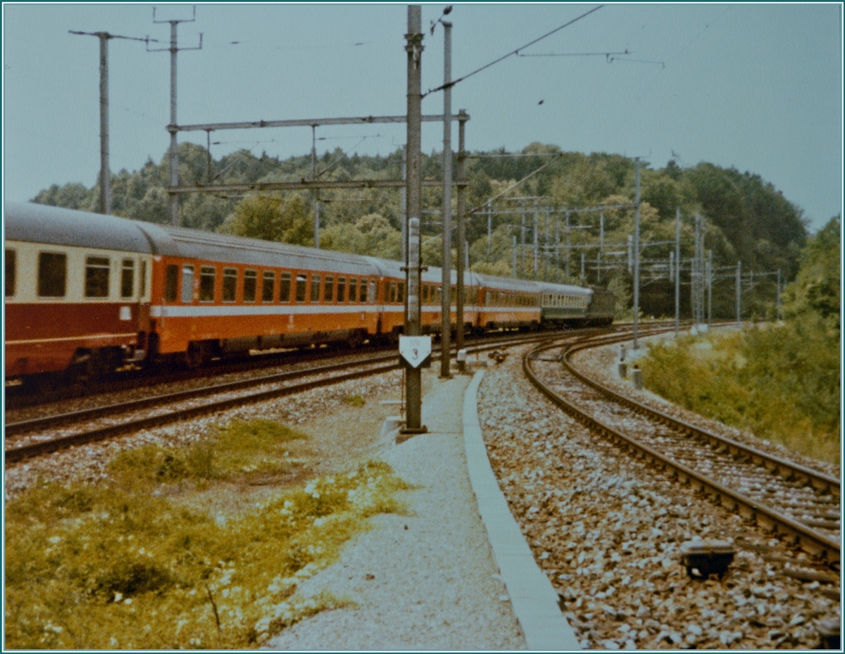 Die SBB Re 6/6 11645  Colombier  ist mit dem IC 20383  Barbarossa  auf dem Weg in den Süden und infolge einer Betriebsstörung auf der Stammstrecke via Freiamt unterwegs und erreicht hier die Abzweigstation Gruemet, wo die Heitersberglinie auf die Strecke von Baden Oberstadt trifft. 

Analogbild vom 16. Juli 1982