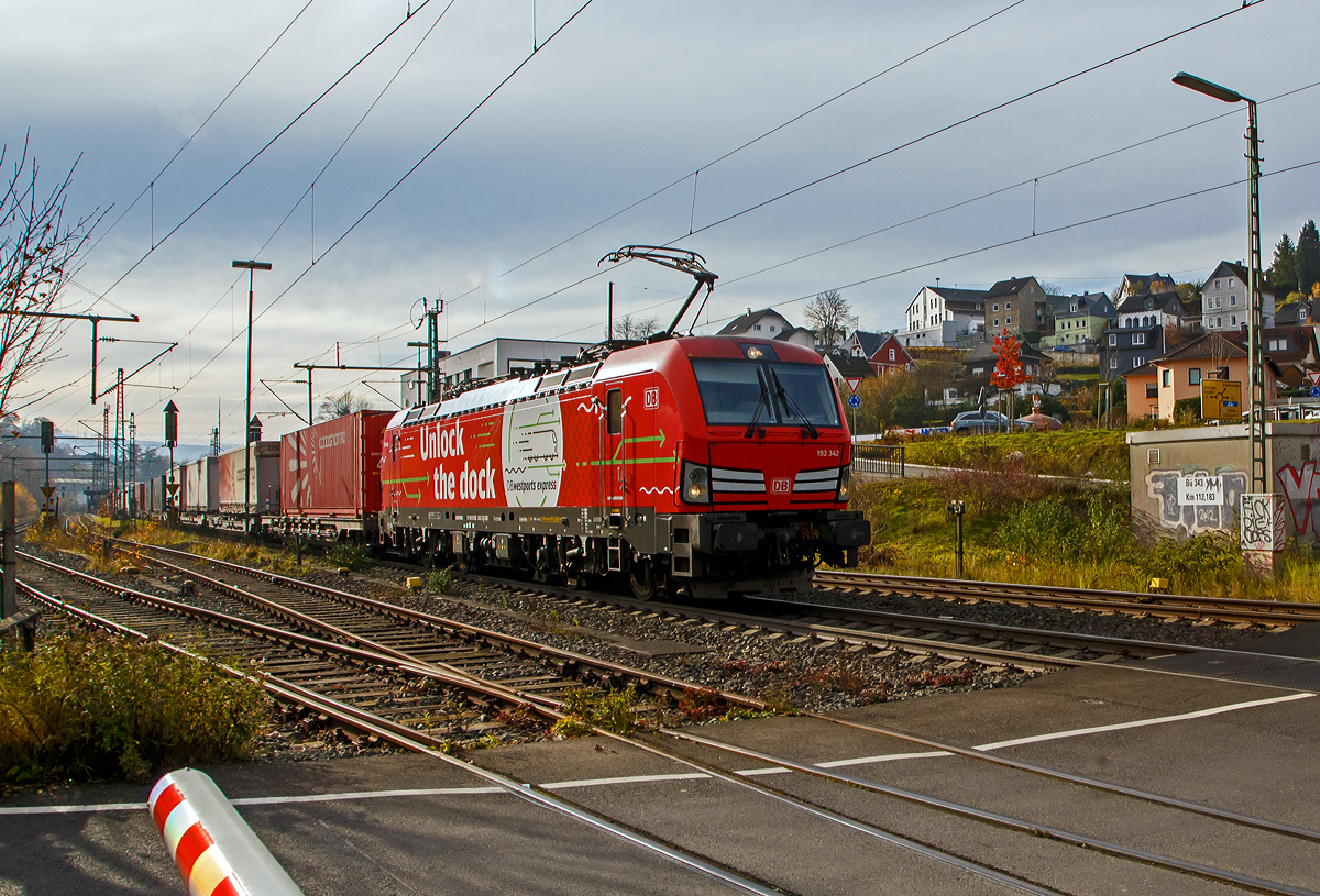 Die Siemens Vectron MS 193 342-3 „Unlock the Dock“ (91 80 6193 343-3 D-DB) der DB Cargo AG fährt am 10.11.2021 mit einem „HUPAC-Zug“ (KLV-Zug) durch Niederschelden in Richtung Siegen.

Die Vectron MS wurde 2018 von Siemens in München unter der Fabriknummer 22422 gebaut und an die DB Cargo geliefert. Diese Vectron Lokomotive ist als MS – Lokomotive (Multisystem-Variante) mit 6.400 kW konzipiert und zugelassen für Deutschland, Österreich, Schweiz, Italien, Belgien und Niederlande, sie hat eine Höchstgeschwindigkeit von 200 km/h. So ist es möglich ohne Lokwechsel vom Mittelmeer die Nordseehäfen Rotterdam oder Hamburg an zu fahren.

Die Vectron MS hat folgende Leistungen:
Unter 15kV, 16,7Hz und 25kV, 50Hz Wechselstrom mit 6.400kW;
unter 3kV Gleichstrom mit 6.000kW sowie
unter 1,5kV Gleichstrom 3.500kW

Auf dem Dach der Lok befinden sich vier Einholmstromabnehmer
Position A Pantograf für AC 1.450 mm breit (für Schweiz)
Position B Pantograf für DC 1.450 mm breit (für Italien)
Position C Pantograf für DC 1.950 mm breit (für Niederlande)
Position D Pantograf für AC 1.950 mm breit (für Deutschland, Österreich), Position D ist hier im Bild vorne.
