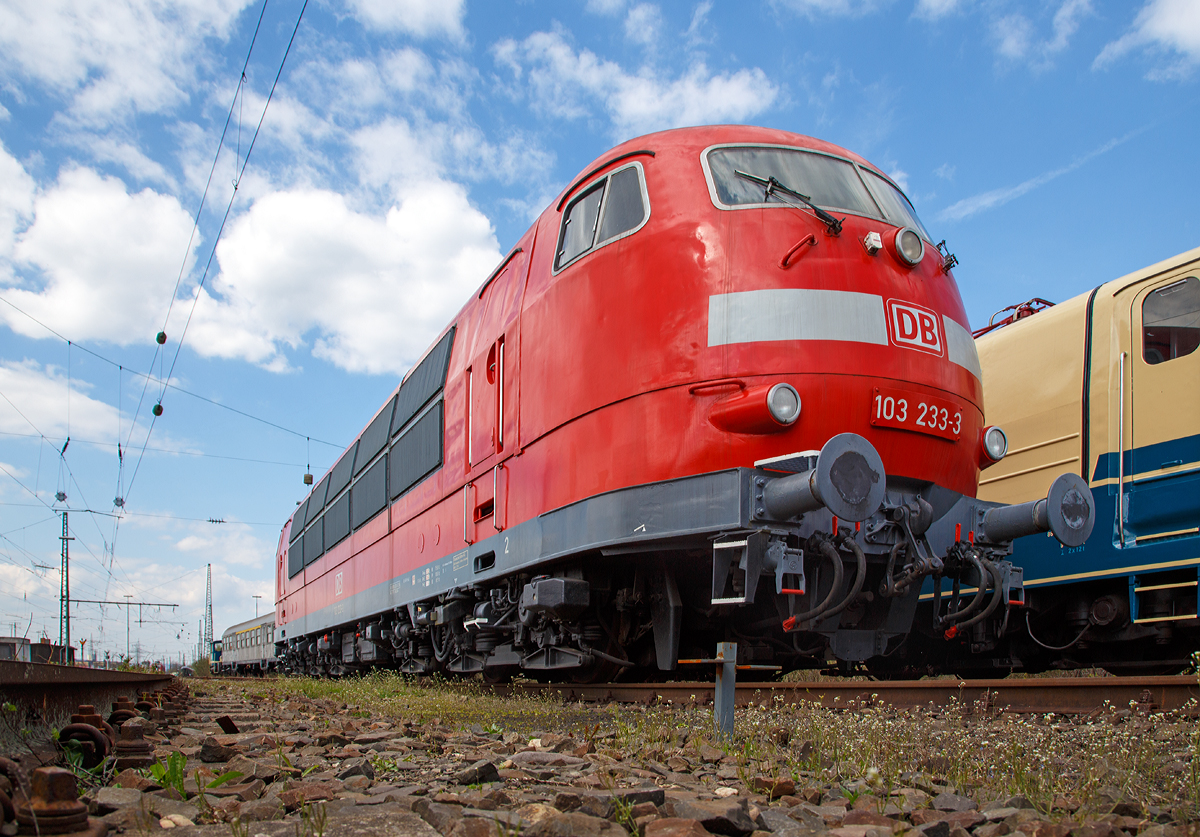 Die stärkste deutsche Lok – Baureihe und einzige Maschine der Baureihe in verkehrsrotem Farbschema, die DB 103 233-3 , am 09.04.2016 beim DB Museum Koblenz-Lützel. Da sie vor dem Tor stand, musste ich meine Kamera unter das Tor halten.

Die 103 233-3 wurde 1973 von Henschel in Kassel unter der Fabriknummer 31780 gebaut, der elektrische Teil ist von BBC (Brown, Boveri & Cie AG). Auf  Initiative vom Modelleisenbahnhersteller Roco wurde sie in verkehrsrot lackiert und so am 5. August 2000 offiziell vorgestellt.

Die Baureihe 103 (Anfangs: E 03) sind schwere sechsachsige Elektrolokomotiven, die im schnellen Reisezugverkehr der Deutschen Bundesbahn (DB) eingesetzt wurden, sie waren lange das Flaggschiff der DB. Mit ihrer Dauerleistung von 7.440 kW (10.116 PS) waren die E 03 bei ihrer Indienststellung die stärksten einteiligen Lokomotiven der Welt und sind die leistungsstärksten Lokomotiven, die die Deutschen Bundesbahn je im Dienst hatte.