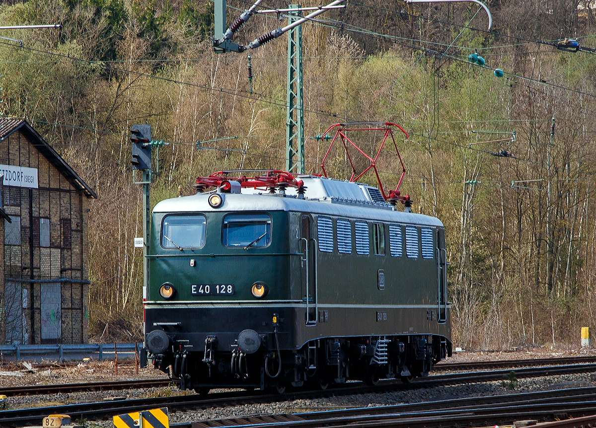 Eigentlich ist Karfreitag, aber es fährt trotzdem viel und außergewöhnliches auf der Siegstrecke...
Im Ursprungszustand die E 40 128 bzw. 140 128-0 (91 80 6 140 128-0 D-DB) vom DB Museum fährt am 02.04.2021, als Tfzf (Triebfahrzeugfahrt) bzw. Lz (Lokzug), durch Betzdorf (Sieg) in Richtung Siegen. Die Lok war auf dem Weg nach Crailsheim.

Die Lok wurde 1959 von Krauss Maffei unter der Fabriknummer 18539 gebaut, der elektrische Teil ist von den Siemens Schuckertwerke, und an die Deutschen Bundesbahn als E40 128 geliefert. Zum 01.01.1968 erfolgte die Umzeichnung in DB 140 128-0. Aus dem aktiven Dienst schied sie 2005 aus und ging ins DB Museum Koblenz-Lützel. Die Lok befindet sich als E40 128 im Ursprungszustand (chromoxidgrün)

Die ab dem Jahr 1968 als Baureihe 140 geführten Loks sind technisch gesehen eine E 10.1 ohne elektrische Bremse, jedoch mit geänderter Übersetzung des Getriebes.
Mit 879 Exemplaren ist die E 40 die meistgebaute Type des Einheitselektrolokprogramms der Deutschen Bundesbahn. Ihre zulässige Höchstgeschwindigkeit betrug am Anfang entsprechend ihrem vorgesehenen Einsatzgebiet im mittelschweren Güterzugdienst 100 km/h, diese wurde im Juni 1969 jedoch auf 110 km/h erhöht, um die Züge zu beschleunigen und die Loks auch besser im Personen-Berufsverkehr einsetzen zu können.

TECHNISCHE DATEN:
Spurweite: 1.435 mm
Achsanordnung: Bo´Bo´
Länge über Puffer: 16.440 mm
Drehzapfenabstand: 7.900 mm
Achsstand in den Drehgestellen: 3.400 mm
Gesamtachsstand: 11.300 mm
Treibrad-Durchmesser: 1.250 mm
Dienstgewicht:  86t
Achslast: 21,5t
Zulässige Höchstgeschwindigkeit: 110 Km/h
Stromsystem: Einphasen-Wechselstrom 15 000 V, 16 ²/₃ Hz
Nennleistung: 3.700 kW (5.032 PS)
Zugkraft: 336 kN
Nennleistung Trafo: 4040 kVA
Anzahl Fahrstufen:  28
Anzahl Fahrmotoren:  4
Fahrmotor-Typ: SSW WB 372

Beschaffungskosten:  ca. 1.226.000 DM