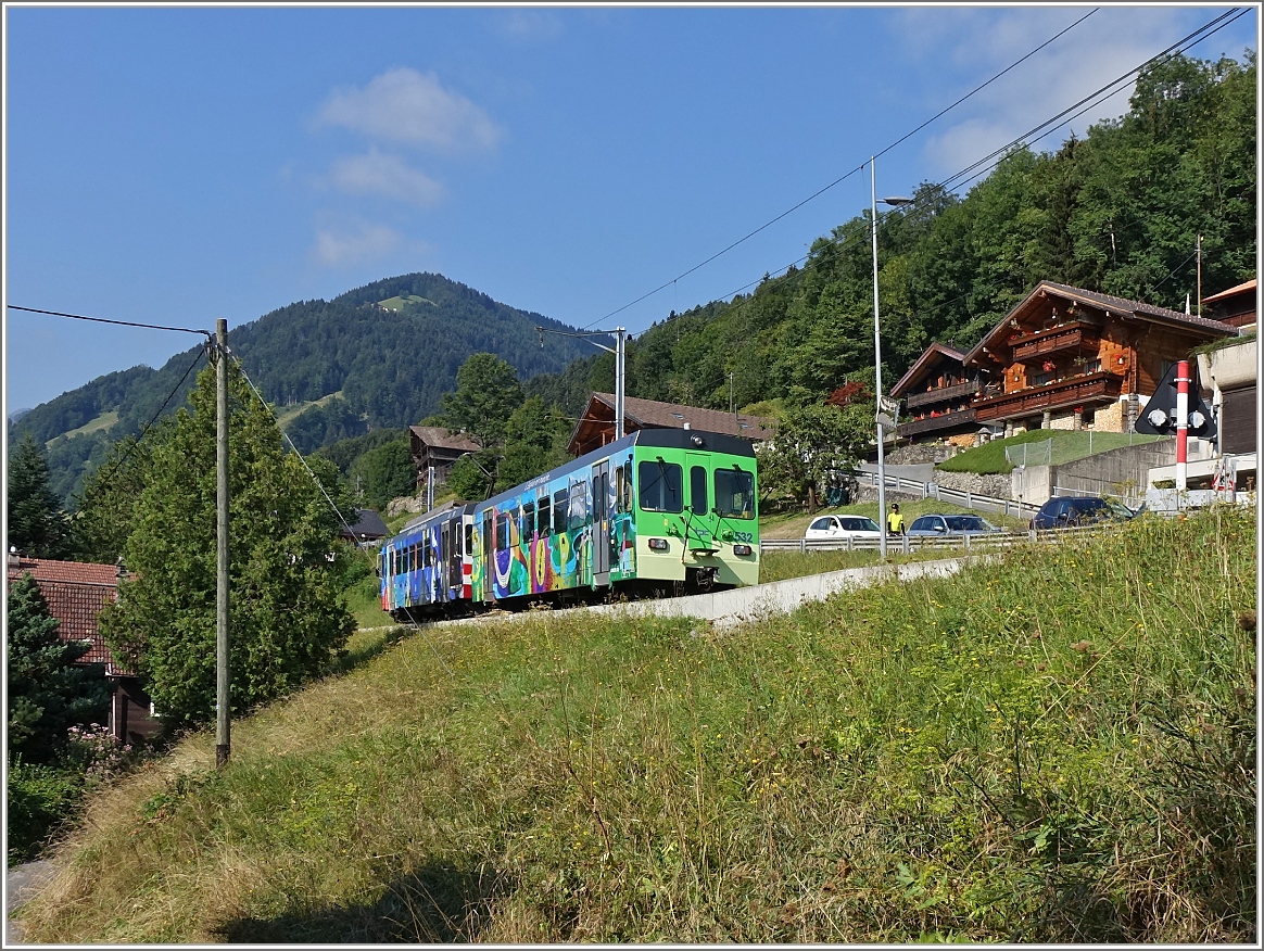 Ein bunter AOMC Regionalzug fährt von Aigle nach Champéry in Troistorrents vorbei.
(11.08.2015)