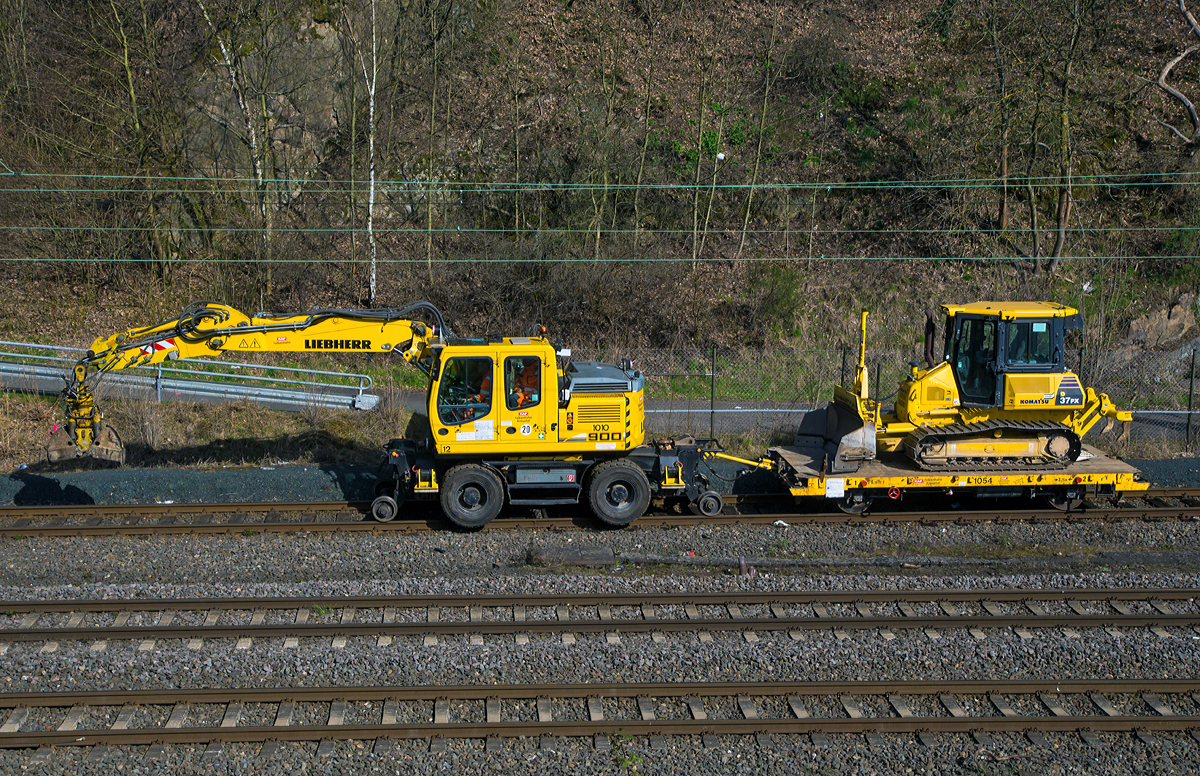 Ein etwas anderer Zugverband....
Ein Liebherr A 900 C ZW Li (Litronic) / 1031, Zweiwegebagger mit Vier-Punkt-Absttzung der KAF Falkenhahn Bau AG, Kreuztal (Nr. 12) mit einem Gleiskraftwagenanhnger Kla 03, beladen mit einer Komatsu Planierraupe D37PX, am 05.04.2015 beim Hauptbahnhof Siegen.