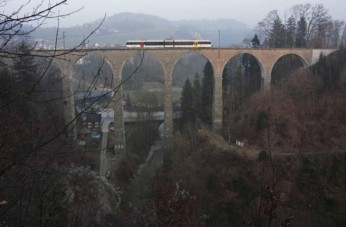 Ein GTW als S9 23970 von Wil nach Nesslau-Neu St. Johann berquert am 05.03.2011 bei Ltisburg den tief eingeschnittenen Hammertobel auf dem Guggenloch-Viadukt.
Der unter dem Viadukt durchflieende Gonzenbach mndet kurz dahinter in die Thur.