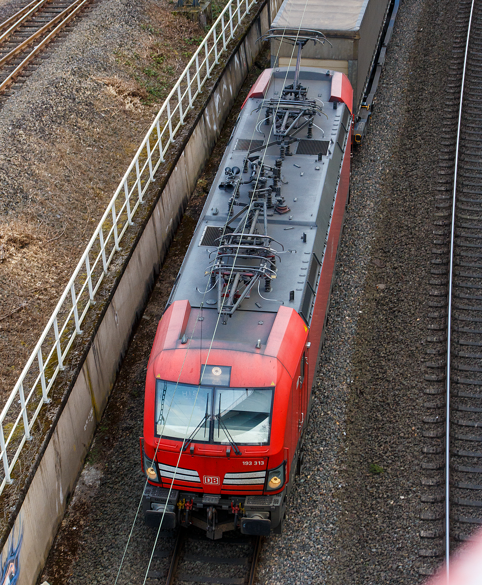 Ein Luftbild der 193 313 von der Brücke in Betzdorf-Bruche.... 
Die 193 313 (91 80 6193 313-4 D-DB), eine Siemens Vectron MS, der DB Cargo AG fährt mit einem KLV-Zug in Richtung Köln. 

Die DB Cargo 193 313 eine Vectron MS wurde 2018 von Siemens in München-Allach unter der Fabriknummer 22414 gebaut und an die DB Cargo geliefert. Diese Vectron Lokomotive ist als MS – Lokomotive (Multisystem-Variante) mit 6.400 kW konzipiert und zugelassen für Deutschland, Österreich, Schweiz, Italien und Niederlande (D/A/CH/I/NL), sie hat eine Höchstgeschwindigkeit von 200 km/h. So ist es möglich ohne Lokwechsel vom Mittelmeer die Nordseehäfen Rotterdam oder Hamburg an zu fahren.