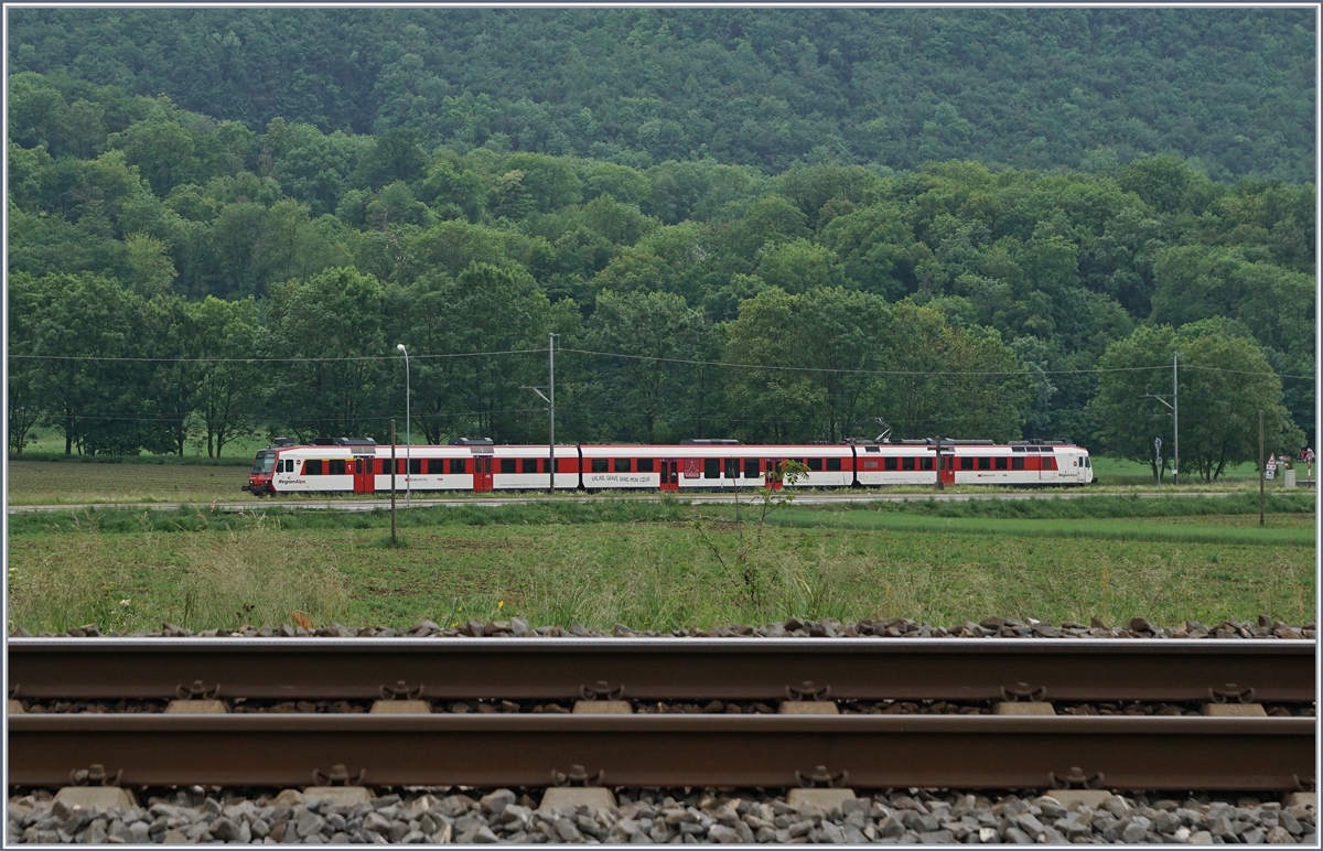 Ein Region Alps Domino ist auf der Strecke von Monthey her auf dem Weg nach St-Maurice, während im Vordergrund das Gleis der Simplon Rhonthal Strecke zu sehen ist.

14. Mai 2020