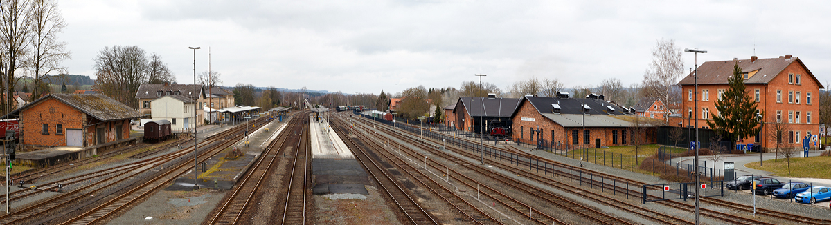 Ein berblick ber den Bahnhof Neuenmarkt-Wirsberg am 26.03.2016 (nrdliche Blickrichtung).  

Links der alte Gterschuppen und das Empfangsgebude, rechts das ehemalige Bahnbetriebswerk Neuenmarkt-Wirsberg, welches seit 1977 das Deutschen Dampflokomotiv Museum (DDM) beherbergt. 

Der Bahnhof liegt an den Bahnstrecken Bamberg–Hof (KBS 820 / KBS 850) und Bayreuth–Neuenmarkt-Wirsberg (KBS 852). Hinter dem Bahnhof in sdlicher Richtung gabelt sich die Strecke, hier beginnt dann u.a. die bekannte Steilstrecke  Schiefe Ebene . Die Rampe nach Marktschorgast berwindet auf 6,8 Kilometern Lnge 157,7 Hhenmeter und hat eine durchschnittliche Steigung von 23 ‰ (max. 40 ‰). Diese war zu Dampflokzeiten eine Herausforderung fr Mensch und Maschine, die meisten Zge mussten mit Schiebelokomotiven nachgeschoben werden. Daher erhielt der Bahnhof Neuenmarkt ein grozgig dimensioniertes Bahnbetriebswerk.

Ich habe mal die Geoposition angegeben, in der Karte kann man dann die Streckenverlufe sehen.