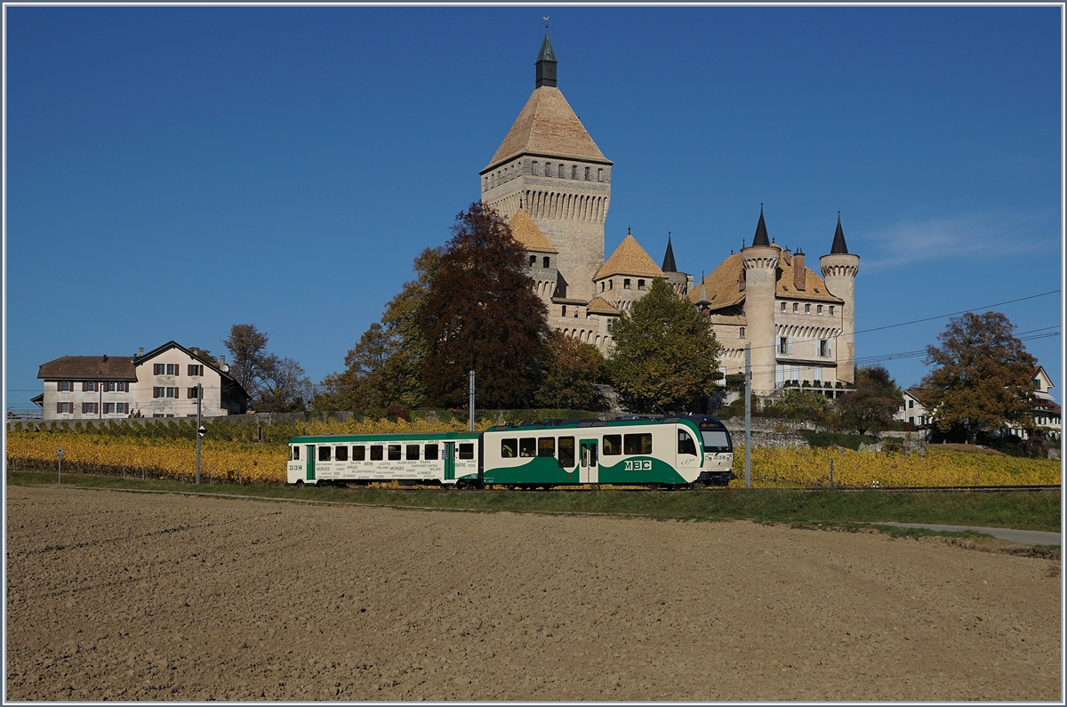 Ein zweiteiliger BAM Regionalzug, bestehend aus einem neuen SURF Be 4/4 und einen  lteren  Bt, auf der Fahrt nach Biere vor der Kulisse des Chteau de Vufflens.
17. Okt. 2017