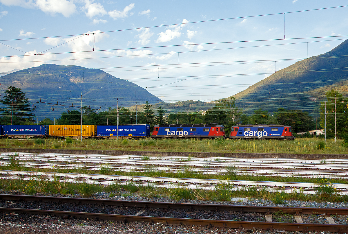 Eine SBB Cargo Re 10/10, bestehend aus der Re 420 344-4 (Re 4/4 – 11 344) und der Re 620 086 (Re 6/6 - 11686 „Hochdorf“), fährt am 04.08.2019 mit einem Container-Zug über die einspurige Güterzugumfahrung Domodossola zum Rangierbahnhof Beura-Cardezza (ex Bahnhof Domodossola II). Diese Strecke ist mit 15 kV 16,7 Hz Wechselstrom elektrifiziert.