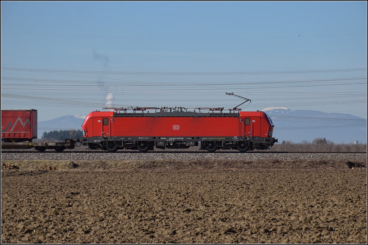 Einer der neuen DB DACHINL-Vectronen 193 330 zieht einen Güterzug an Auggen vorbei. Februar 2019.