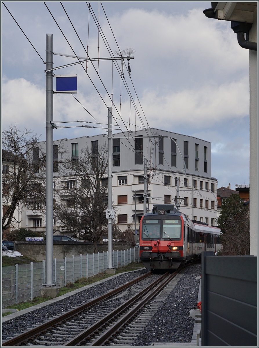 Erneut ist ein Normalspurzug auf dem Weg nach Broc, diesmal ein SBB RBDe 560  Domino  als RER 4014 von Düdingen nach Broc. Die Aufnahme entstand bei Bahnübergang der Rue du Moléson. 

22. Dezember 2022