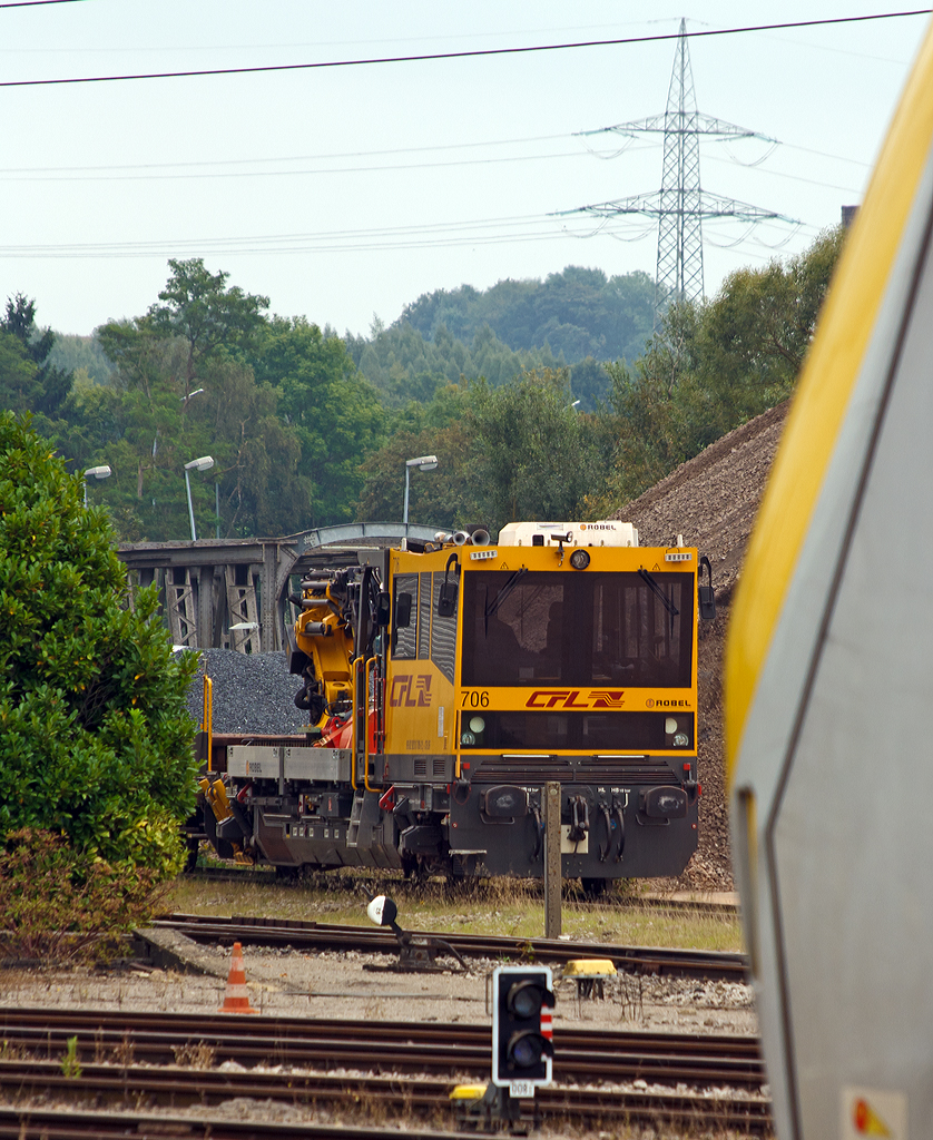 
Etwas versteckt abgestellt ist der CFL Robel IIF 706 (99 82 9210 706-2 L CFL IF) am 14.09.2014 beim Bahnhof Ettelbrück (Ettelbréck). 

Das Interventions- und Instandhaltungsfahrzeug (IIF) draisine - Robel 54.22 wurde 2010 von ROBEL Bahnbaumaschinen gebaut. Die deutsche Bezeichnung wäre Gleisarbeitsfahrzeug BAMOWAG 54.22 

CFL (Société Nationale des Chemins de fer Luxembourgeois, die luxemburgische Staatsbahn) Série /Baureihe: 700
Anzahl bei CFL :  12
Hersteller:  ROBEL Bahnbaumaschinen
Spurweite: 1.435 mm Zahl der Radachsen : 2 Achsformel: B
Länge über Puffer:  15.100 mm
Eigengewicht: 36,5 t
Leistung: 500 KW
Höchstgeschwindigkeit:  100 km/h 
Anmerkungen: Ausgestattet mit Kran Palfinger PR 220D