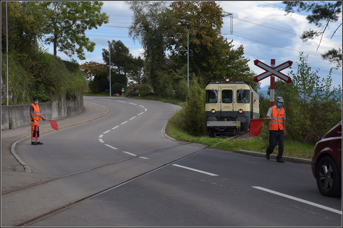 Fahrtag Wolfhuuser Bahn.

Passage des Bahnübergangs am Ortsende Wolfhausen, vorne der ABt der IG Stammgleis Wolfhausen–Bubikon. Oktober 2021.