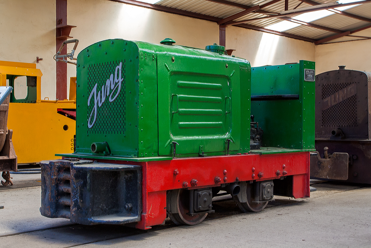 Feldbahn Diesellok Jung EL 110 (Baujahr 1936 unter Fabrik-Nr. 6610) im Feld- und Grubenbahnmuseum Fortuna (FGF Lok 53) am 07.07.2013 in Solms-Oberbiel. 

Die Firma Arnold Jung Lokomotiv-Fabrik GmbH aus Jungenthal bei Kirchen an der Sieg ist bekannt für eine außerordentlich vielfältige Lokomotivproduktion. In der über 100 jährigen Geschichte des Lokomotivbaues bei Jung nahmen Schmalspur-, Gruben- und Feldbahnlokomotiven stets einen wichtigen Platz ein. Seit den 1920er Jahren wurden in Jungenthal auch Feldbahn-Diesellokomotiven gefertigt. Der Loktyp EL 110 zählt zu dem Jung Diesellokprogramm der 2. Generation und wurde von 1934 bis 1963 in einer Stückzahl von ca. 900 Loks gefertigt. Die Lok ist mit dem Einzylinder Zweitaktmotor SE 110 (Stehender Einzylinder Zweitaktmotor mit einem Kolbendurchmesser von 110 mm, 11/12 PS) ausgerüstet. Über ein mechanisches Vierganggetriebe können Geschwindigkeiten von 3 bis 13 km/h erreicht werden.

Diese Feldbahnloktype war früher weit verbreitet. Von ihrer kleineren Schwester, der Type EL 105 unterscheidet sie sich hauptsächlich durch das mit Ganghebel zu schaltende Viergang-Getriebe. Die Lok wiegt 4 t, hat eine Leitung von 11-12 PS und eine Höchstgeschwindigkeit von 13 km/h.

Die Bezeichnung EL steht für Einzylinderlokomotive und die Zahl 110 weist auf den eingebauten Motor vom Typ SE 110 (110 mm Kolbendurchmesser) hin. Die S-Motortypenreihe stellt die zweite bei Jung entwickelte und gebaute Dieselmotoren-Generation dar. Die Motoren arbeiteten nach dem Zweitaktprinzip, sind wassergekühlt und besitzen Umlaufschmierung. Der Spüldruck wird im Kurbelgehäuse mittels Blattfeder-Einlaßventilen und Stufenkolben erzeugt. Als Direkteinspritzer sind die Motoren außerordentlich startfreudig und benötigen keine Lunte zum Ankurbeln. 

Die Lok hat zum Antrieb der Achsen nachspannbare Präzisons-Rollenketten. Die Klotzbremse wirkt über ein Hebelsystem ebenfalls auf beide Achsen. Ergonomisch vorteilhaft ist dabei, dass der Lokführer den Hebel zum Bremsen von sich wegdrücken muss und dafür guten Halt durch die Rückenlehne hat.

TECHNISCHE DATEN:
Hersteller: Arnold Jung Lokomotivfabrik GmbH, Jungenthal bei Kirchen an der Sieg
Typ:   EL 110
Fabriknummer: 6610
Baujahr: 1936
Spurweite: 600 mm
Achsfolge B
Dienstgewicht: 4,0 t
Leergewicht: 3,9 t
Länge über Puffer: 2.930 mm
Breite: 1.025 mm
Achsabstand: 780 mm  
Zugkraft: 775 kg (7,75 kN)
Fahrgeschwindigkeit:  3 - 5 - 8 - 13 km/h
Kleister Kurvenradius: 8,0 m
Bremse: Hand / mechanisch
Antrieb: Kette
Motor: Jung wassergekühlter stehender Einzylinder,2-Takt Dieselmotor mit Direkteinspritung vom Typ SE 110 (Fabriknummer 3085), Hubraum 1,8 l
Leistung: 11 / 12 PS bei 1000 U/min (Dauer- / Höchstleistung)
Getriebe: mechanisches Vierganggetriebe Jung Typ 12F (Fabriknummer 1051)
Anlasser: manuell mit Kurbel