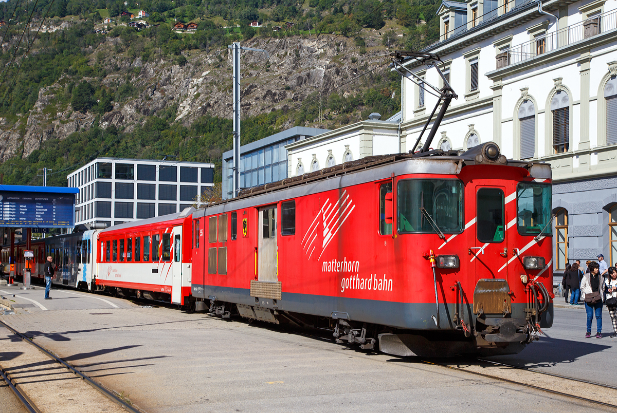 
Geschoben von dem elektrischen Zahnradtriebwagen Deh 4 /4 – 55 „Brig“ erreicht der MGB Regionalzug von Andermatt am 16.09.2017 den Bahnhof Brig.

Der Gepäcktriebwagen wurde 1972 gebaut, der Lokomotivkasten ist von SIG, die Triebdrehgestelle von SLM und die elektrische Ausrüstung von BBC.

Da das Rollmaterial in den 60er Jahren großenteils veraltet und der Verkehr in der Wintersaison stark angestiegen war, benötigte die FO dringend leistungsfähigere Triebfahrzeuge. Man entschied sich für leistungsfähige Gepäcktriebwagen, die freizügig auf dem gesamten Netz eingesetzt werden konnten. Die fünf Fahrzeuge des Typs Deh 4/4 wurden 1972 bestellt und lösten die HGe 2/2 und die ABDeh 2/4 ab, die den Wintersportverkehr auf der Schöllenenbahn nicht mehr bewältigen konnten. 

Ein Nachbau der FO-Deh 4/4 erhielt einen völlig andersartigen Kasten, weshalb diese Fahrzeuge bei der FO als Deh 4/4 I und II unterschieden wurden. Seit der Fusion zur MGB ist diese Bezeichnung nicht mehr gebräuchlich, die MGB unterscheidet die Serien nach den Nummernbereichen 21, 51 und 91. Wobei sie sich schon optisch und auch technisch etwas unterscheiden.

Technische Daten Deh4/4 I (51-55):
Spurweite: 1.000 mm
Achsformel: Bo'zz Bo'zz
Länge über Puffer: 16.900 mm
Größte Breite: 2.650 mm
Größte Höhe (bei abgesenkten Stromabnehmer): 3.880 mm
Leergewicht: 48,3  t 
Dienstgewicht: 50,3 t
Maximale Zuladung: 2,0 t
Höchstgeschwindigkeit: Adhäsion 60 km/h / Zahnstange 30 km/h
Stundenleistung: 1.032 kW
Dauerleistung: 936 kW
Treibraddurchmesser:  790 mm (Adhäsion) / 688 mm (Zahnrad)
Stromsystem: 11 kV 16,7 Hz AC
Anzahl der Fahrmotoren: 4
Größe der Ladefläche: 11,5 m2
