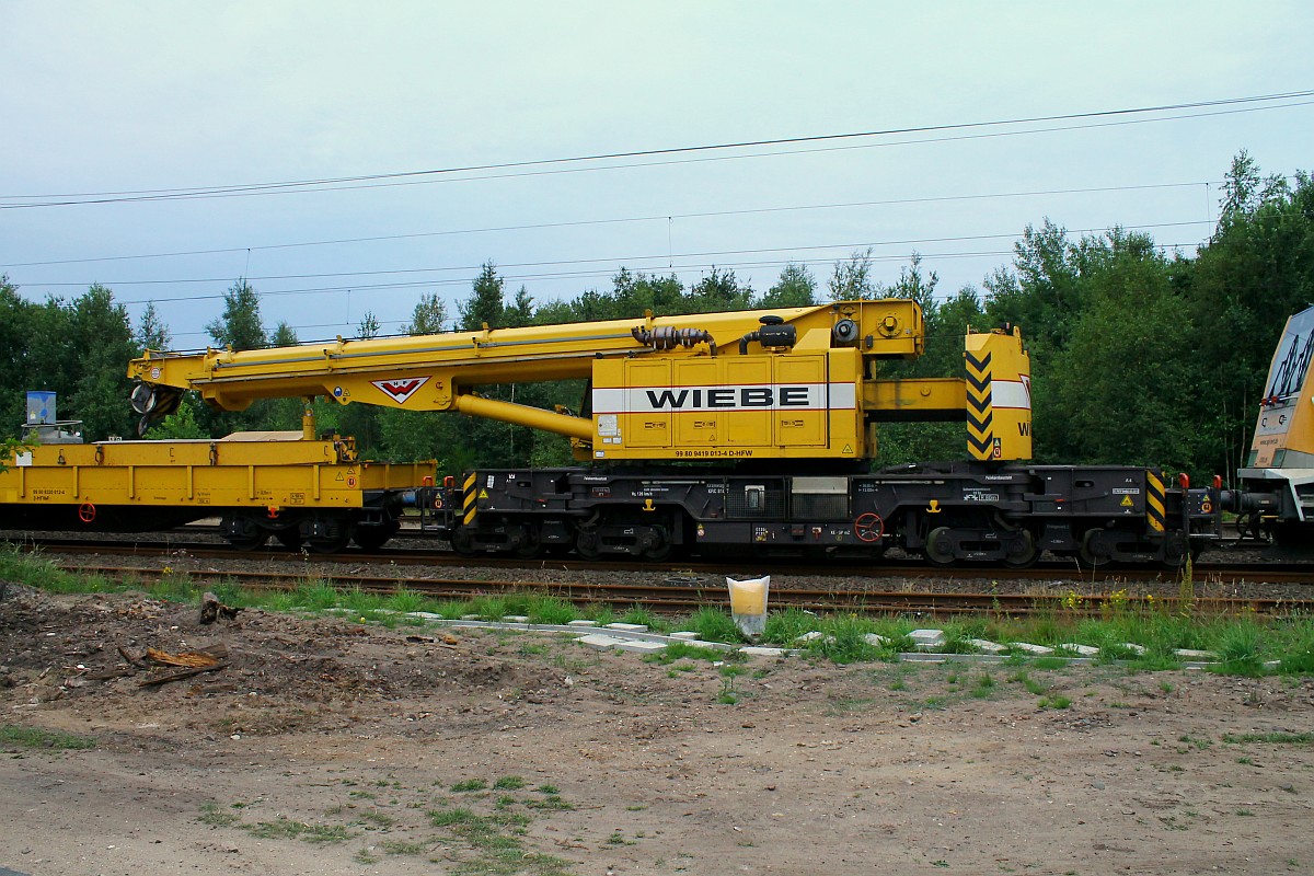 Gleisbauschienenkran KRC 810T der Firma H.F Wiebe registriert unter 9980 9419 013-4(REV/GKR/02.03.2012) mit Kran-Schutzwagen(nur angedeutet)9980 9320 012-4 D-HFW abgestellt am 24.07.2015 in Jübek bei Schleswig.