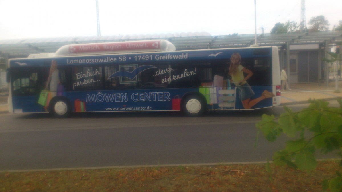 ...Greifswalder Busbahnhof es fahren schon einige Stadtverkehr dieser MAN die auch die Werbung von den alten Fahrzeugen bernommen haben....hier fr das Mwencenter in Schneiche die vorher an einem Citaro zusehen war 