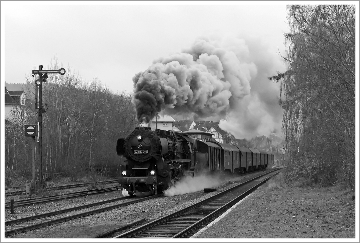 Herdorf Anno 1963 - Die Betzdorfer 52 8134-0 zieht mit mchtiger Rauchfahne dem Mittagszug.... 

Nein im Ernst mit mchtiger Rauchfahne durchfhrt die Betzdorfer 52 8134-0 am 01.12.2013 Herdorf, hier kurz vor dem Bahnhof. Heute veranstalten die Eisenbahnfreunden Betzdorf ihre alljhrlichen Nikolausfahrten zwischen Betzdorf/Sieg und Wrgendorf.

Die Lok war, bedingt durch die Wiedervereinigung, eine der letzten Normalspurigen Dampfloks der DB.  Zudem war sie als 052 134-4 die einzige wahre 52 der DB (BR 52.80). Die Lok wurde 1965 aus der 1943 bei der Lokfabrik Wien-Floridsdorf (Fabriknummer 16591) gebauten 52 7138 rekonstruiert.
